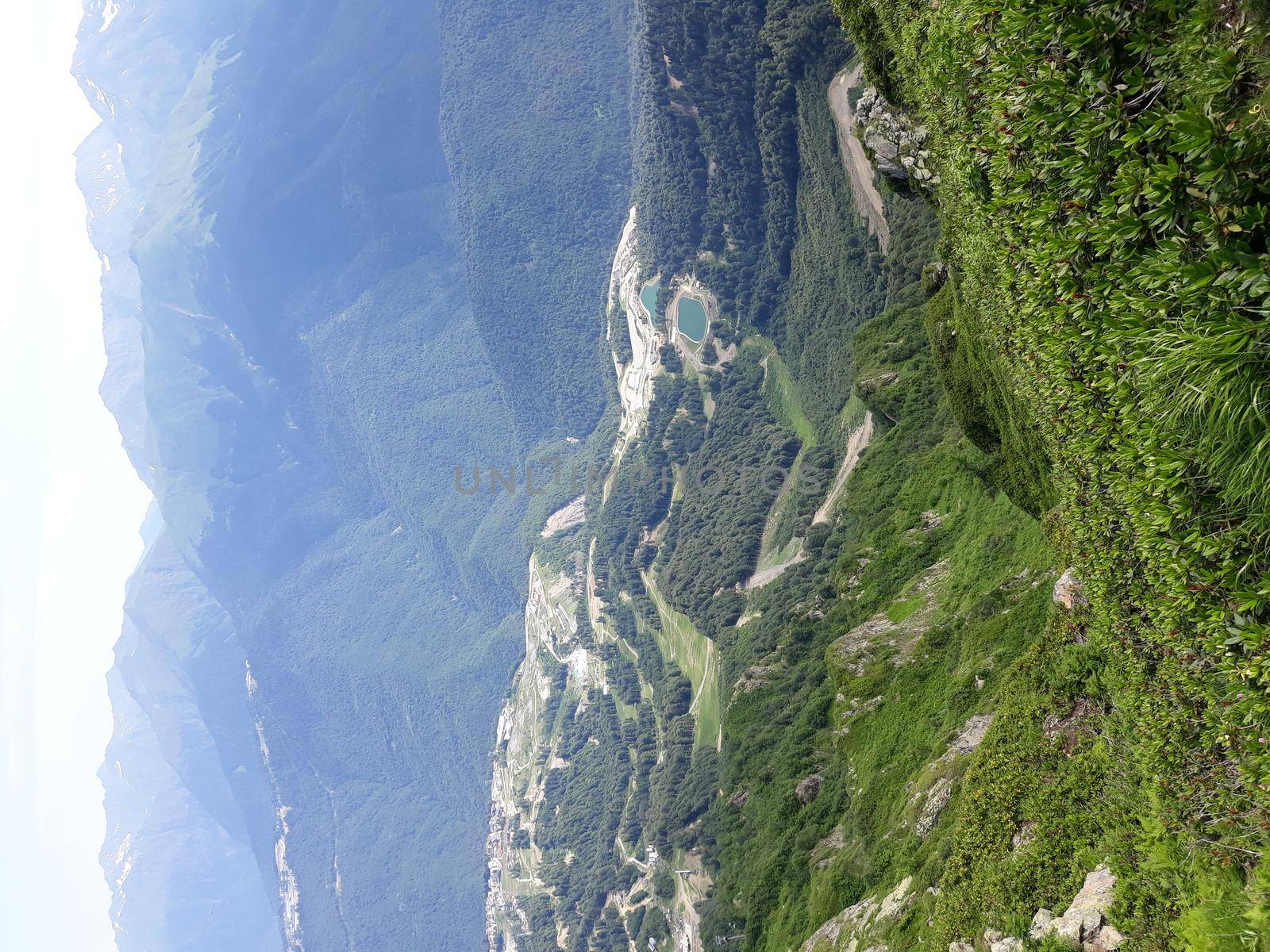 Panoramic mountain landscape with valleys and forested mountain peaks.