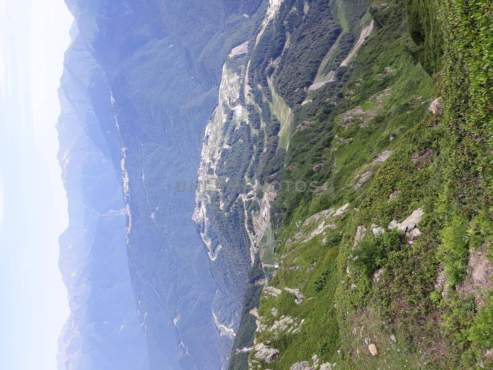 Panoramic mountain landscape with valleys and forested mountain peaks.