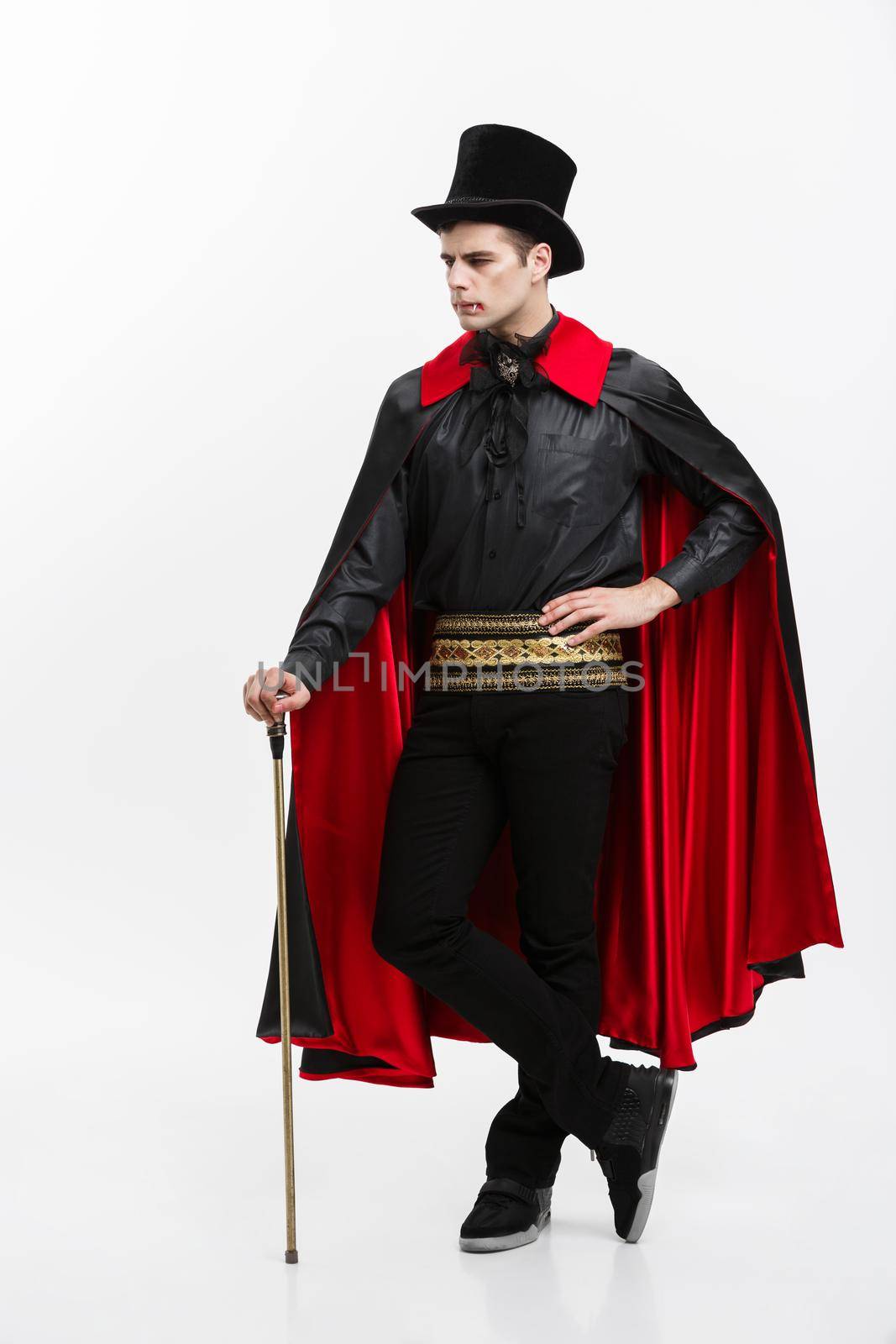 Vampire Halloween Concept - Full length Portrait of handsome caucasian Vampire in black and red halloween costume