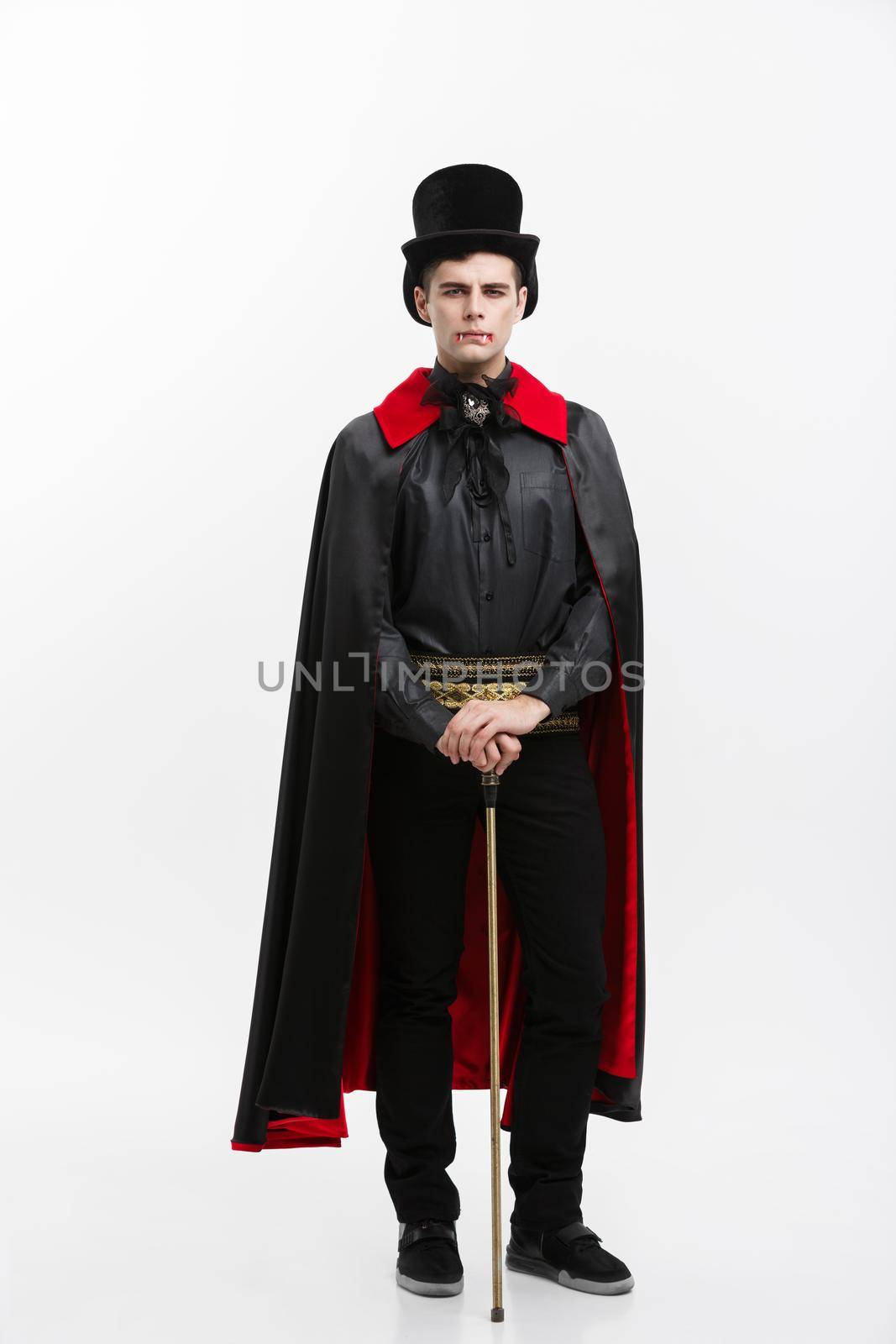 Vampire Halloween Concept - Full length Portrait of handsome caucasian Vampire in black and red halloween costume. by Benzoix