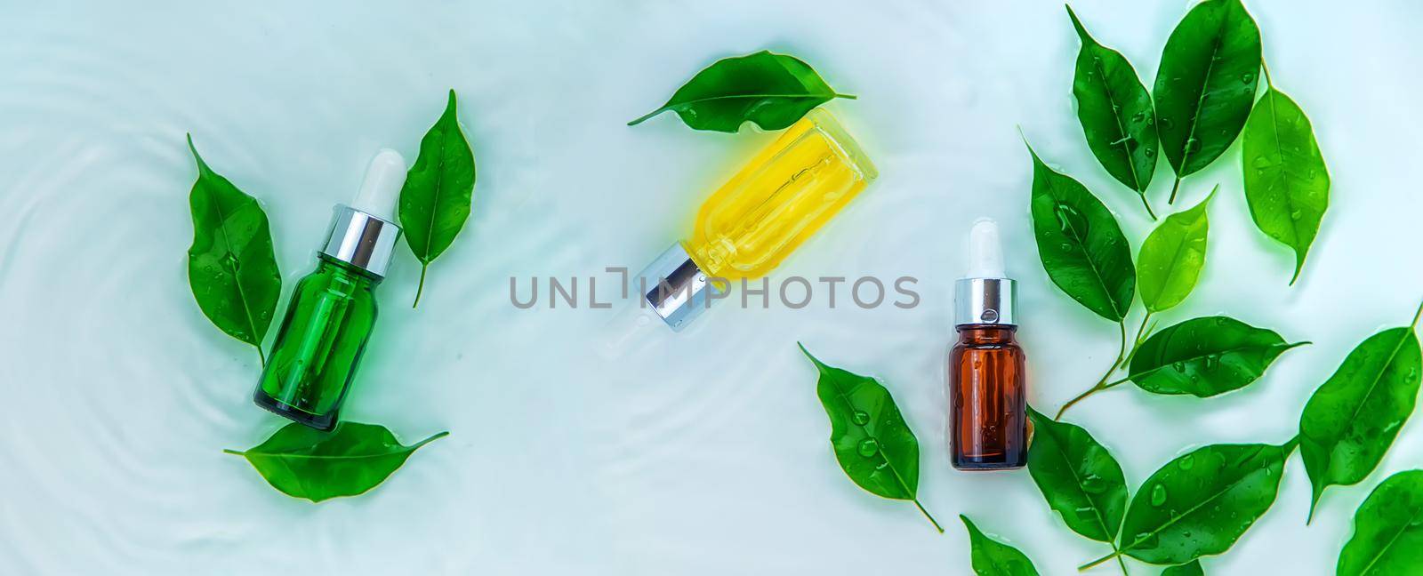 Cosmetics in a bottle in water, skin hydration concept. Selective focus. Nature.