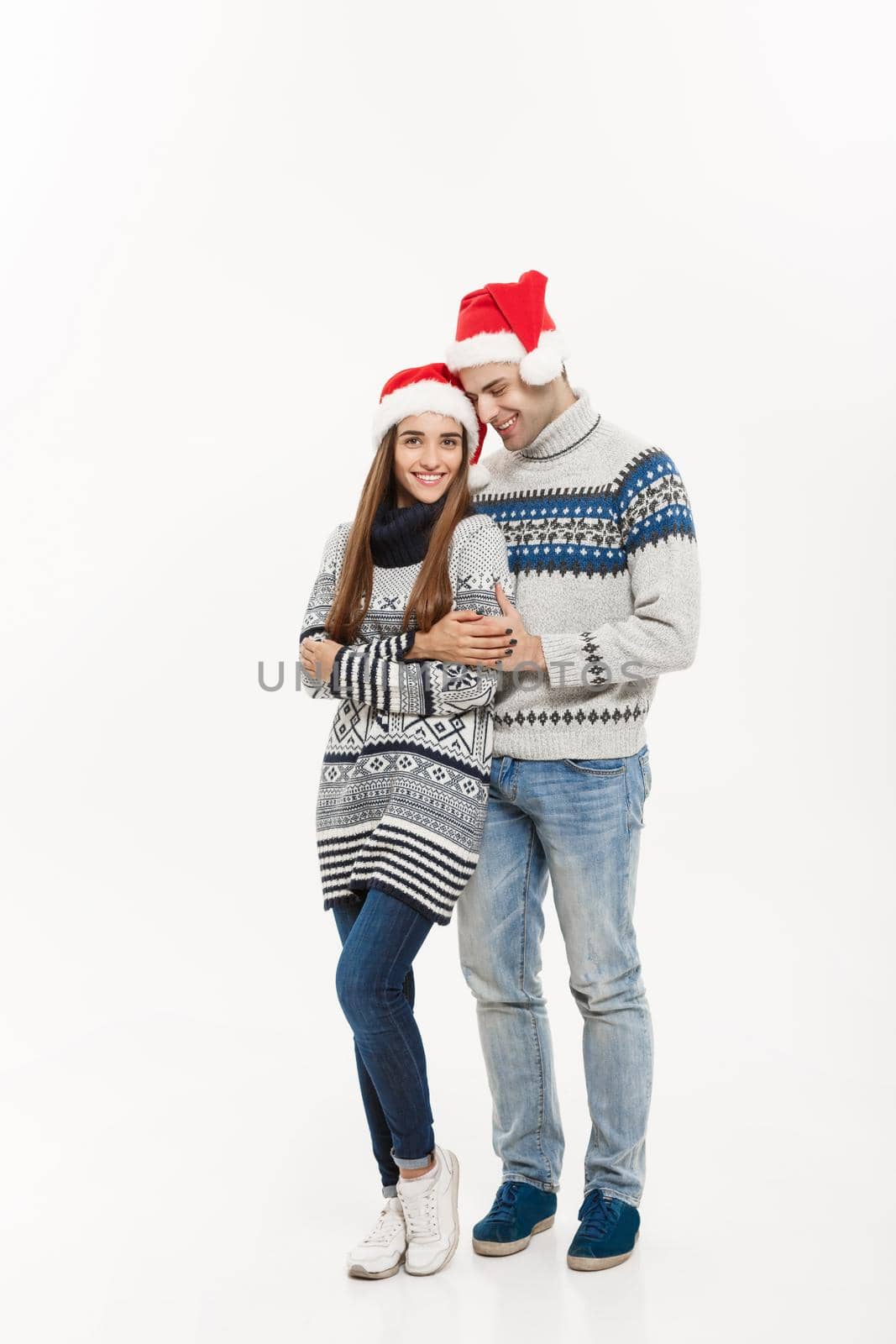 Christmas concept - Full-length Young attractive caucasian couple giving a hug celebrating for Christmas day. by Benzoix