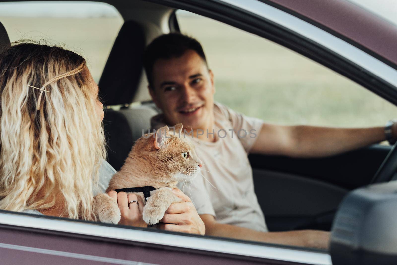 Happy Couple with Their Red Cat Enjoying Road Trip, Young Woman and Man Traveling by Car with Pet by Romvy