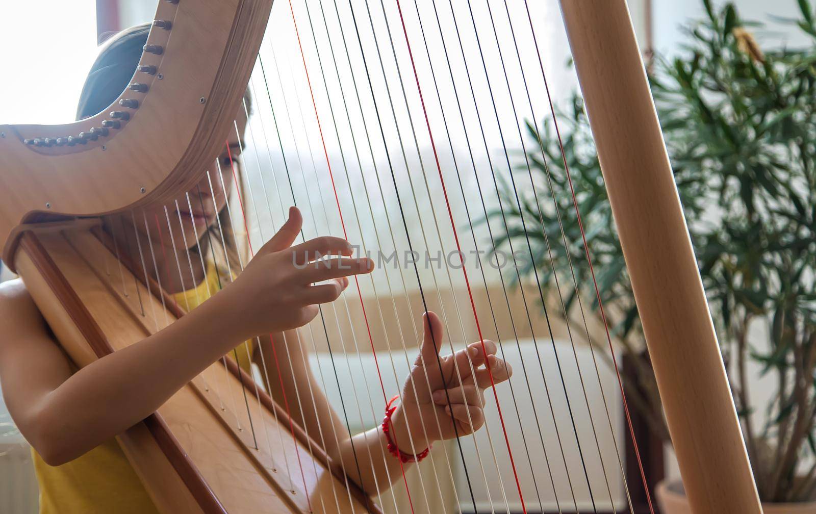 The child plays the harp. Selective focus. Kid.