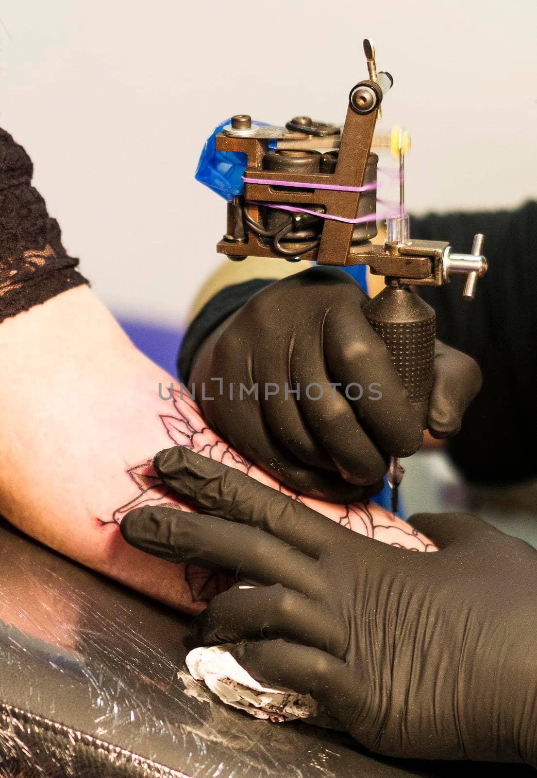 a tattoo artist draws a flower on a person's skin.