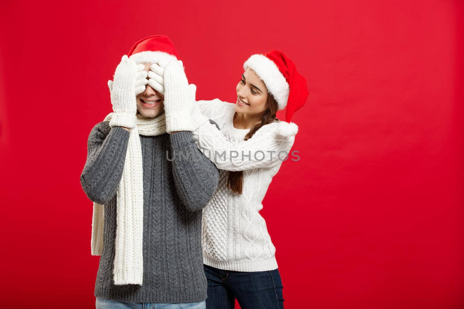 Christmas Concept - portrait lovely girlfriend surprising close her boyfriend eyes in Christmas day by Benzoix