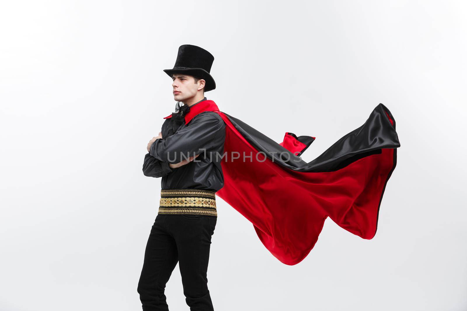 Vampire Halloween Concept - Portrait of handsome caucasian Vampire halloween costume fluttering his red, black cloak. by Benzoix