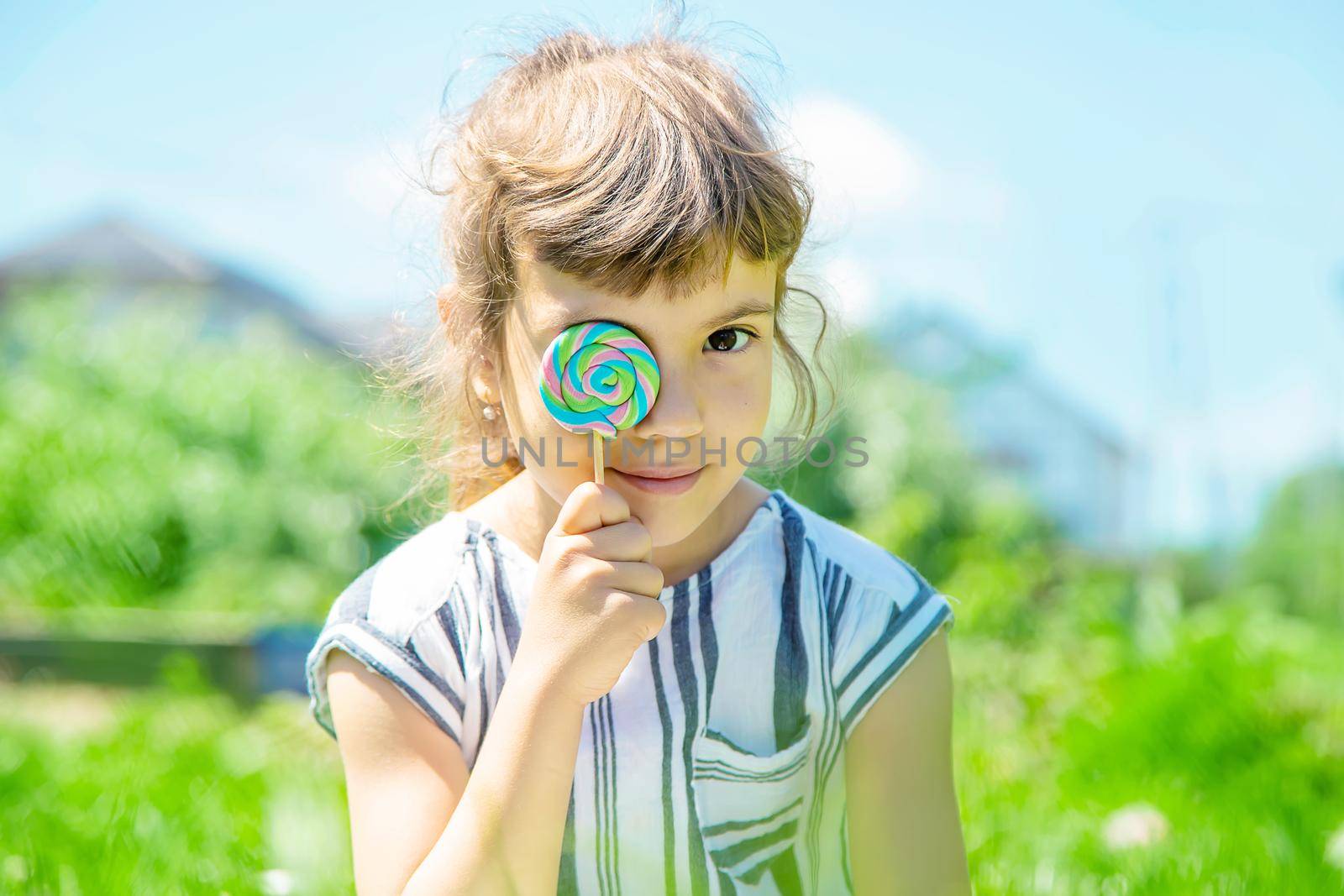 child eats lollipop on nature. Selective focus.