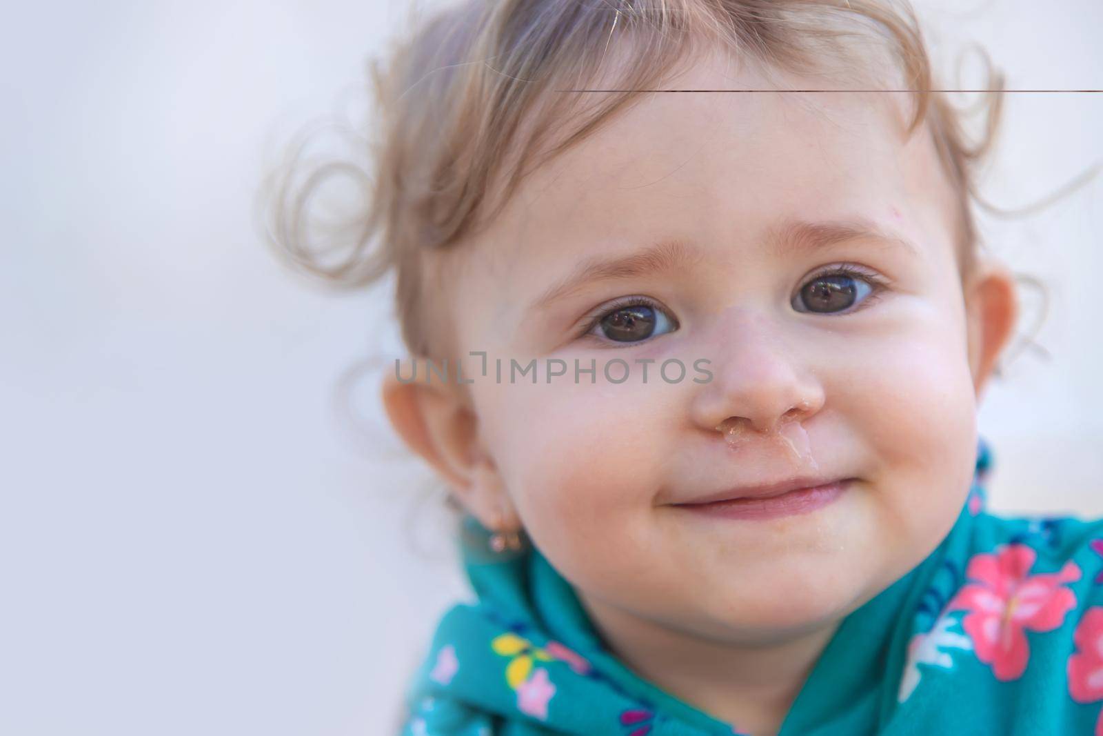 Baby plays snot in the street with a cold nose. Selective focus. Child.