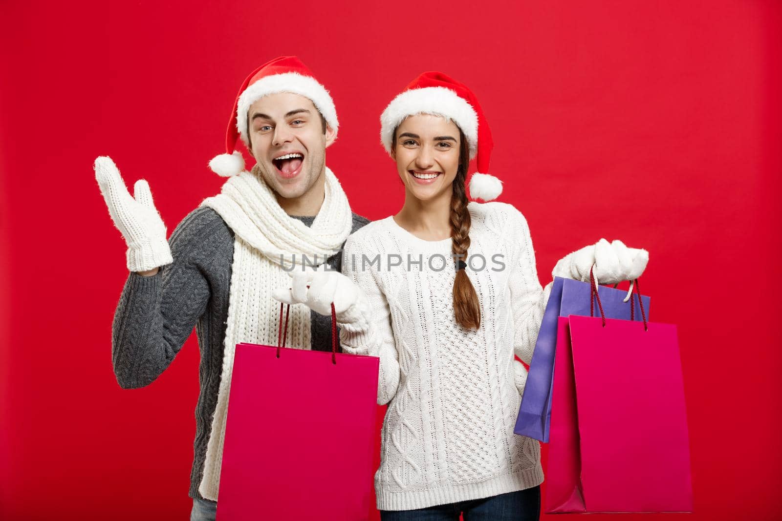 Christmas Concept - Young attractive couple holding shopping bag enjoy shopping and celebrating in Christmas day.
