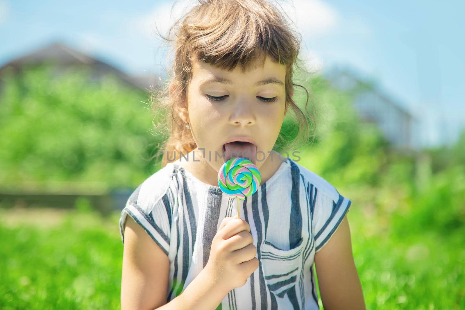 child eats lollipop on nature. Selective focus.