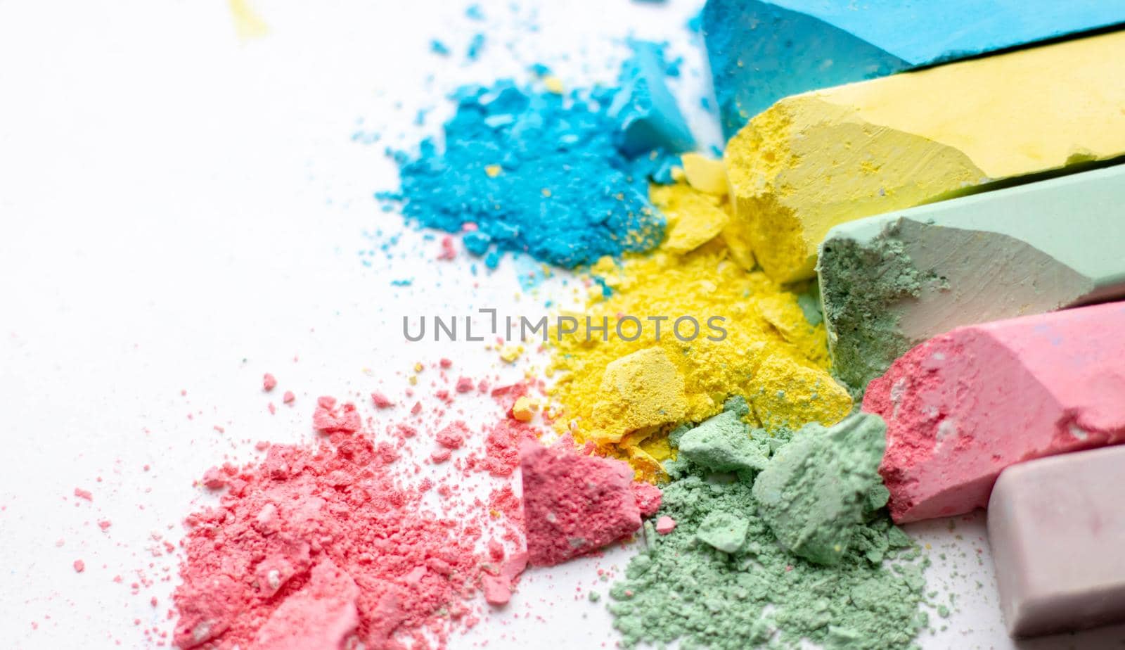 Crumbs of multi-colored chalk on a white background. A game for children. Art by lapushka62
