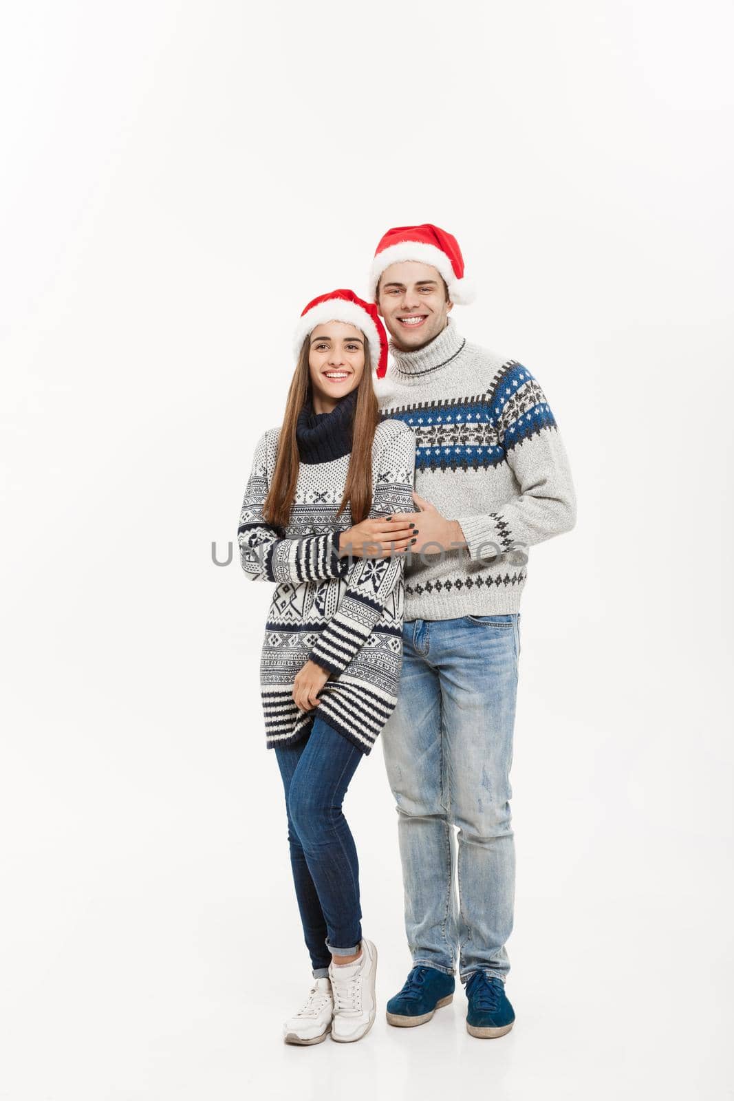 Christmas concept - Full-length Young attractive caucasian couple giving a hug celebrating for Christmas day. by Benzoix
