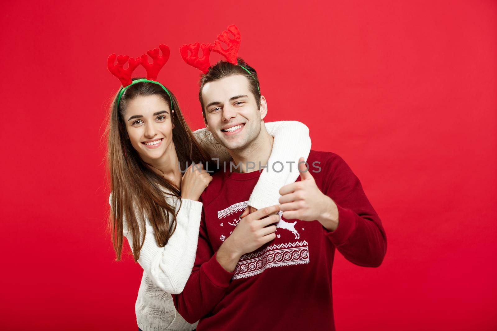 Christmas Concept - Romantic couple in a christmas sweaters huging each other.