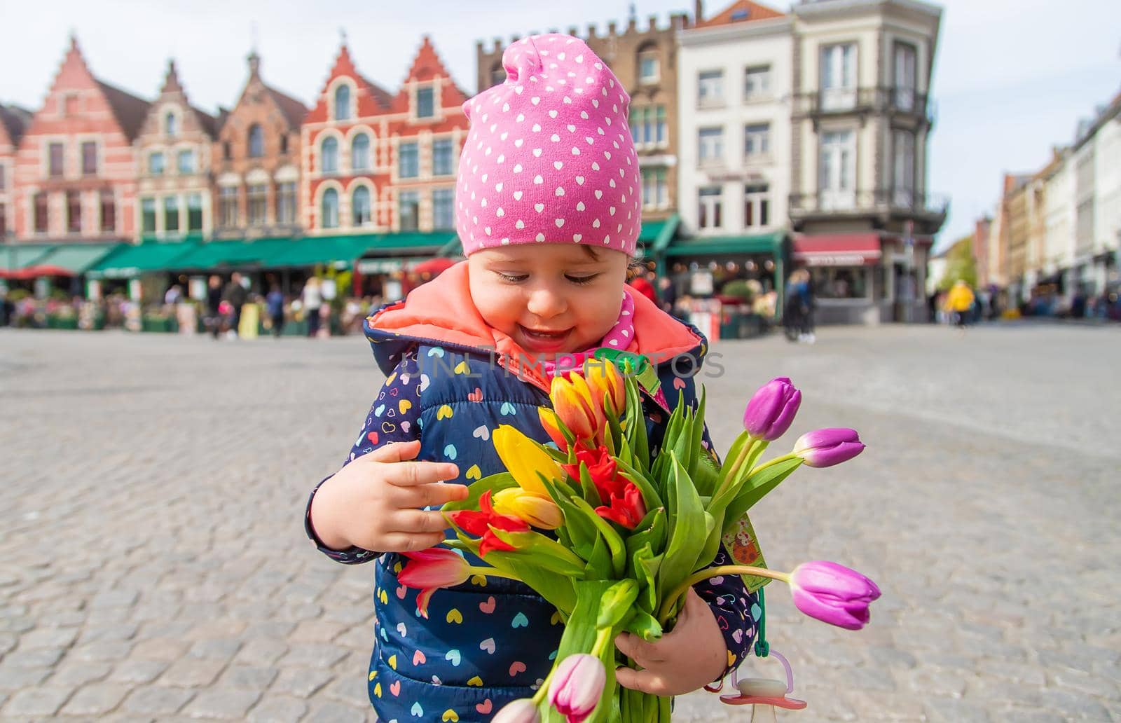 Bruges Belgium - April 23, 2022 a child with a bouquet of tulips. Selective focus. Nature.