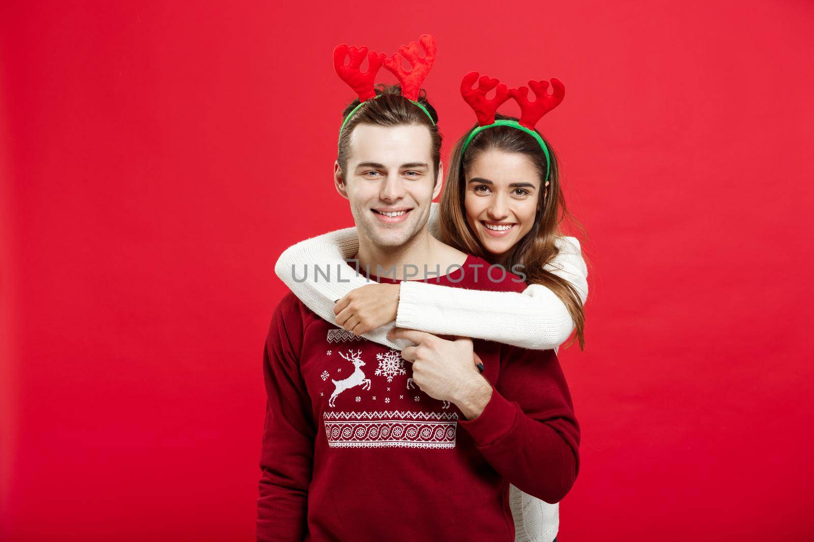 Christmas Concept - Romantic couple in a christmas sweaters huging each other by Benzoix