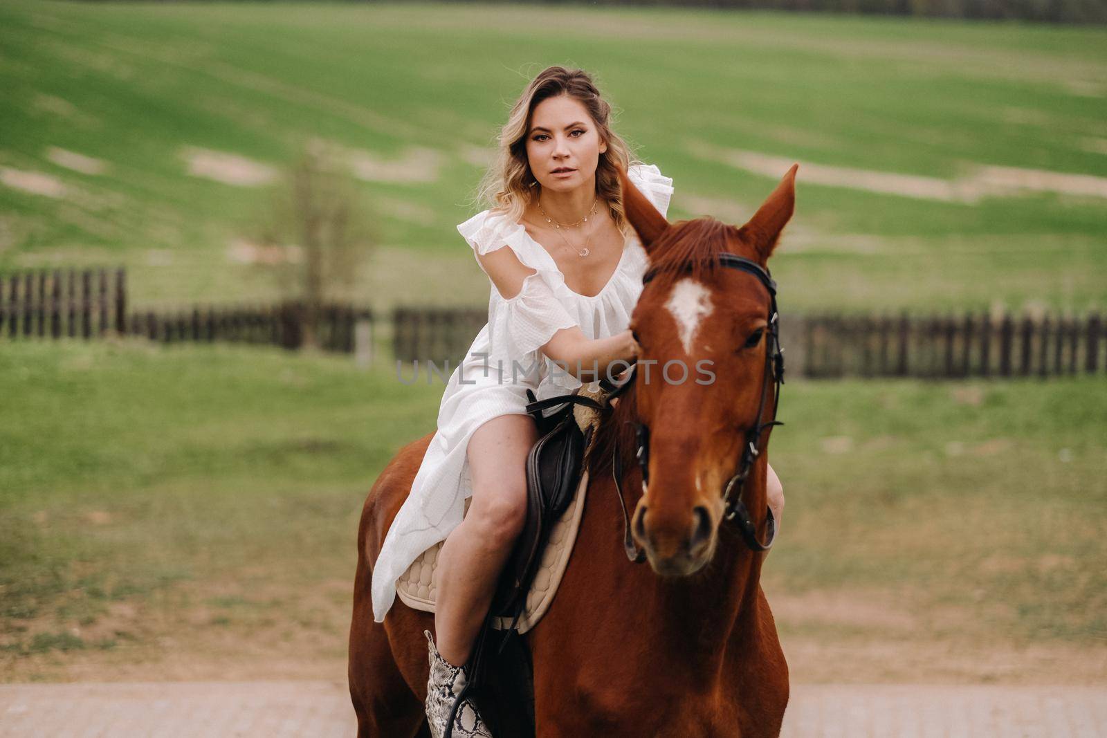 A woman in a white sundress riding a horse in a field by Lobachad