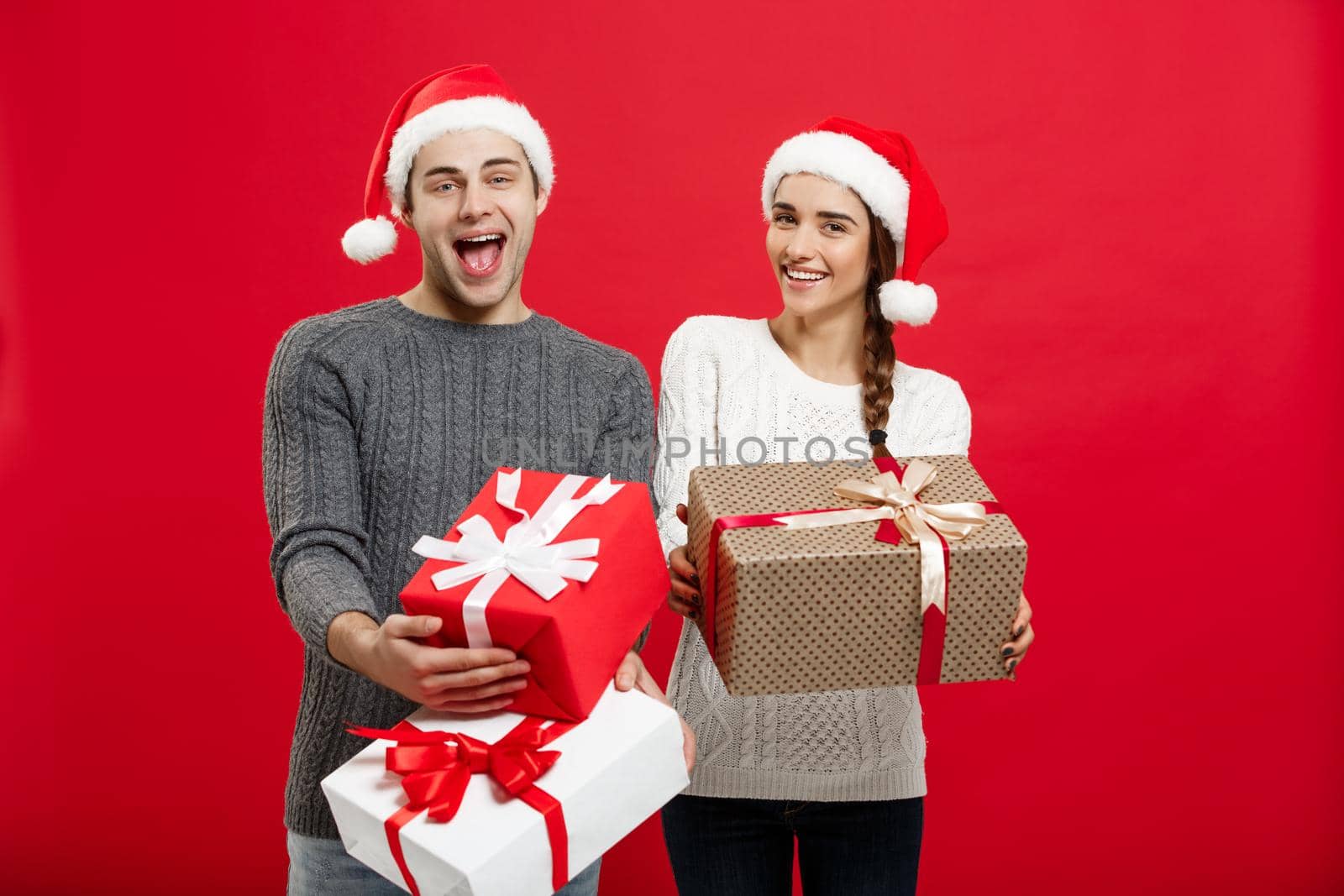 Christmas Concept - Young attractive couple holding a lot of presents enjoy shopping and celebrating in Christmas day.