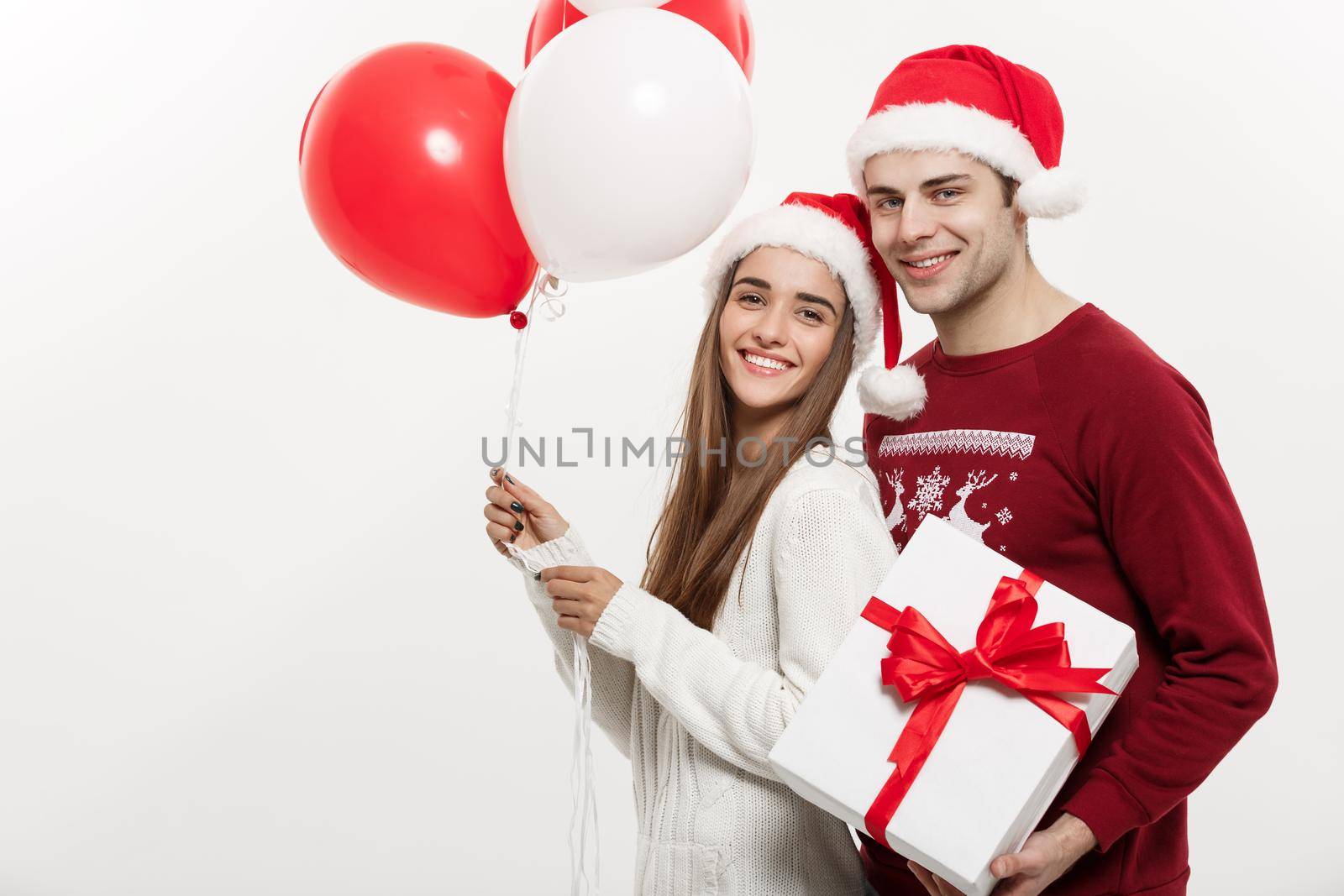 Christmas Concept - Young girlfriend holding balloon is hugging by Benzoix