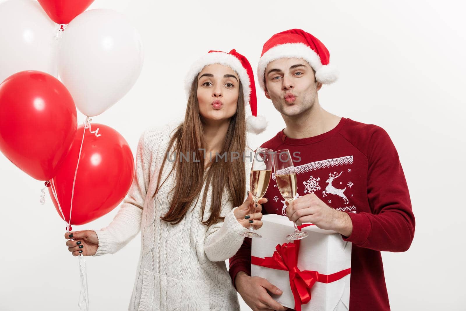 Christmas Concept - Young girlfriend holding balloon and champagne playing and celebrating with her boyfriend on Christmas day by Benzoix