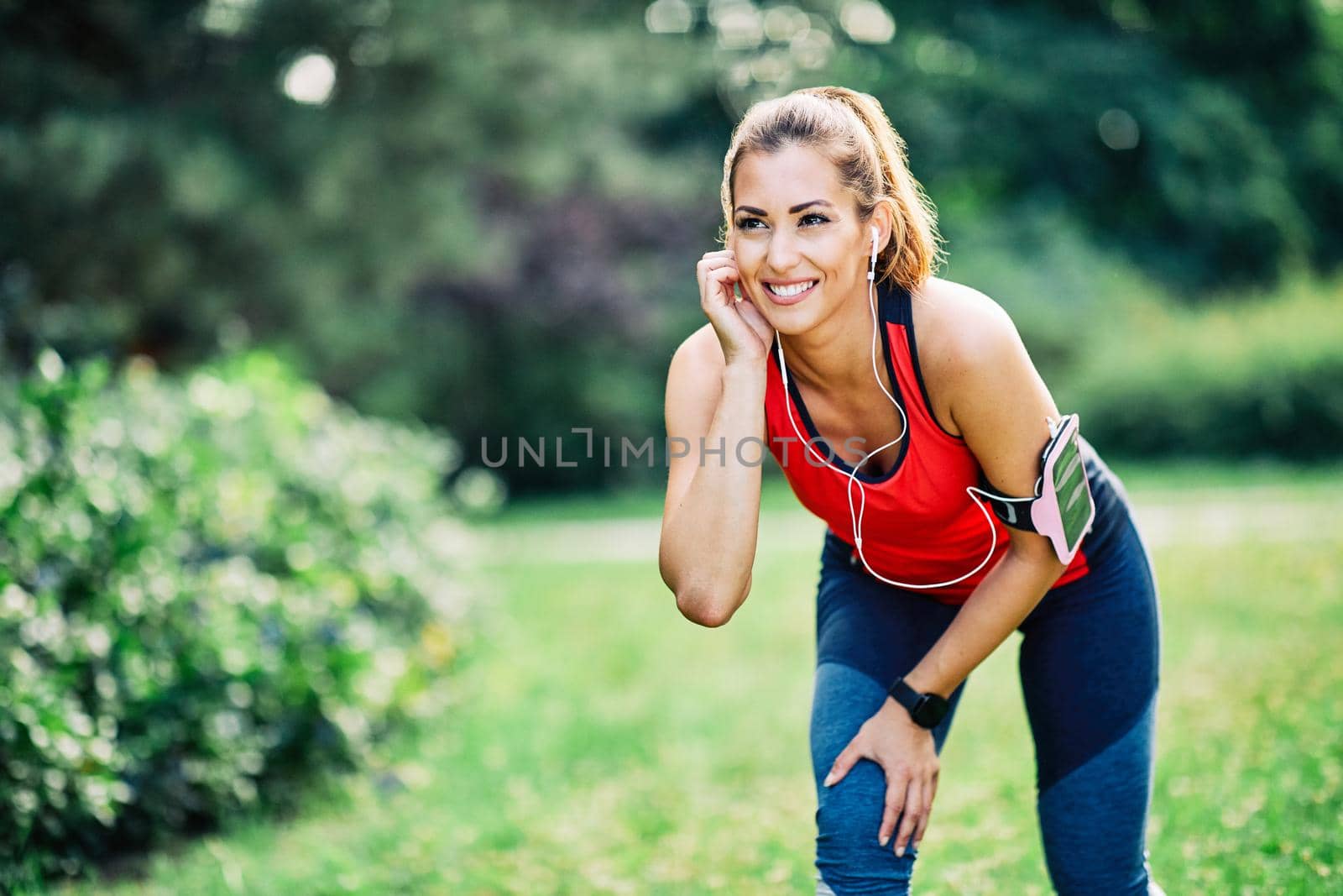 Portrait of a young fitness woman exercising in a park outdoors