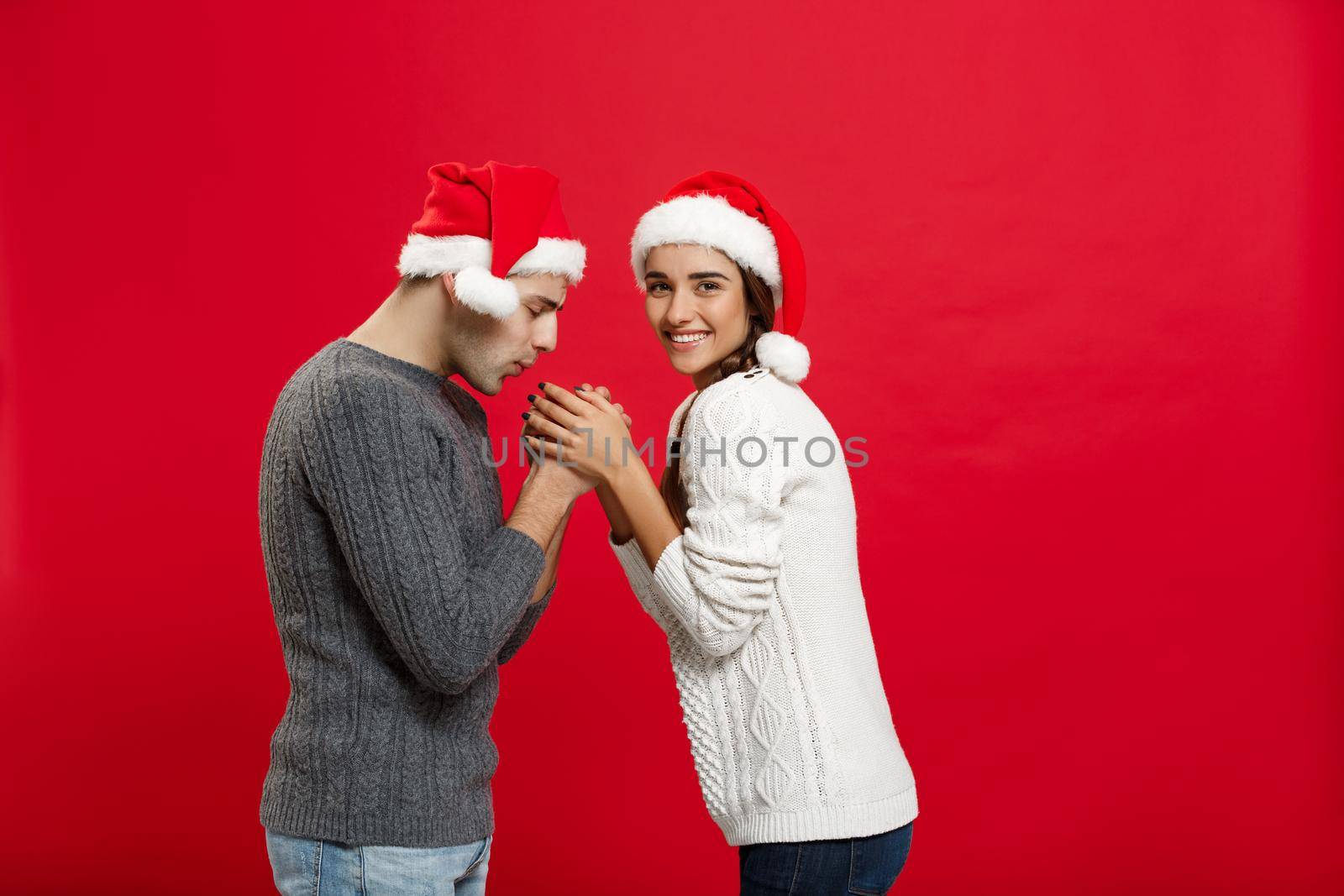 Christmas Concept - young stylish couple holding hand each other by Benzoix
