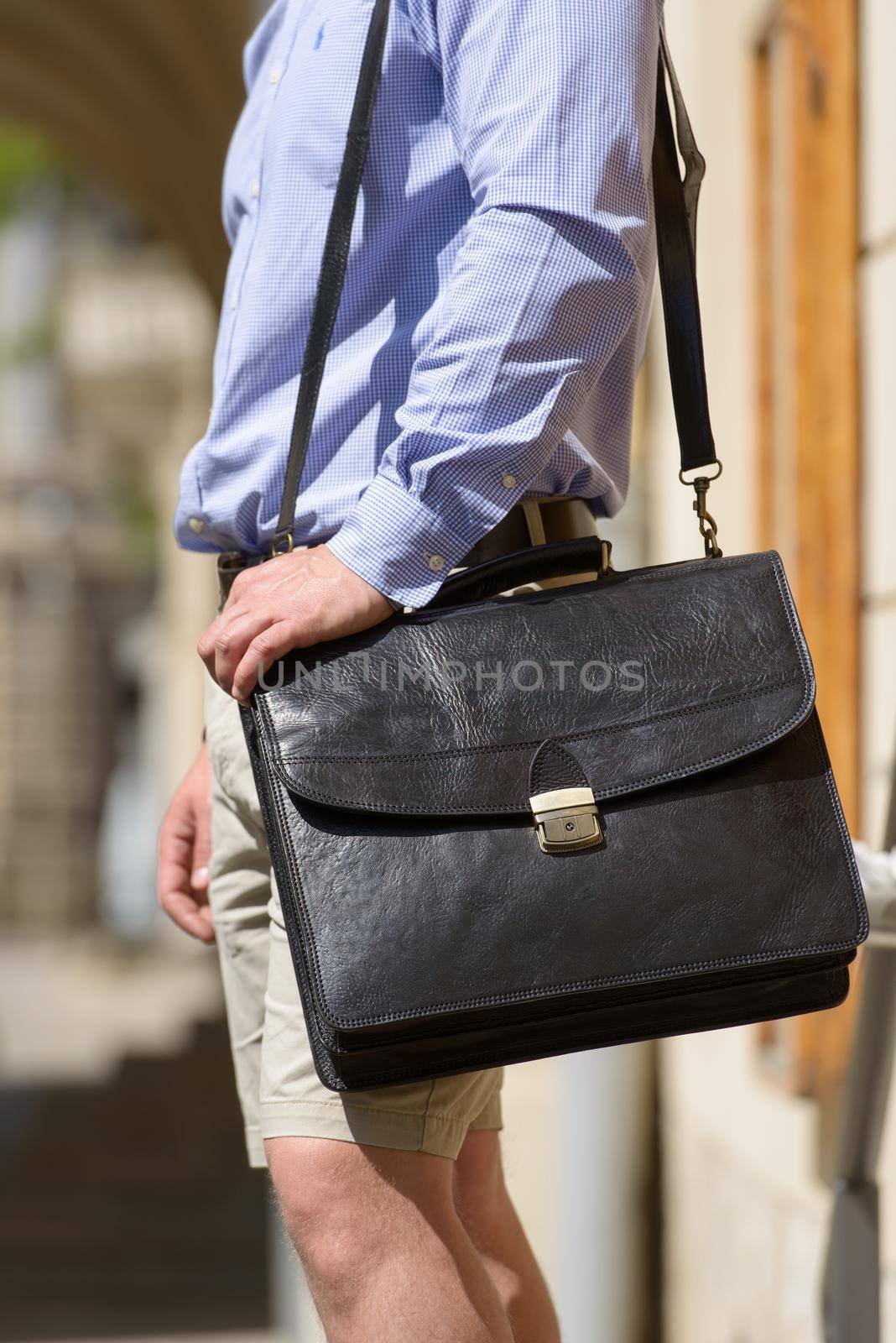 Part photo of a man with a brown leather briefcase with antique and retro look. Outdoors photo by Ashtray25