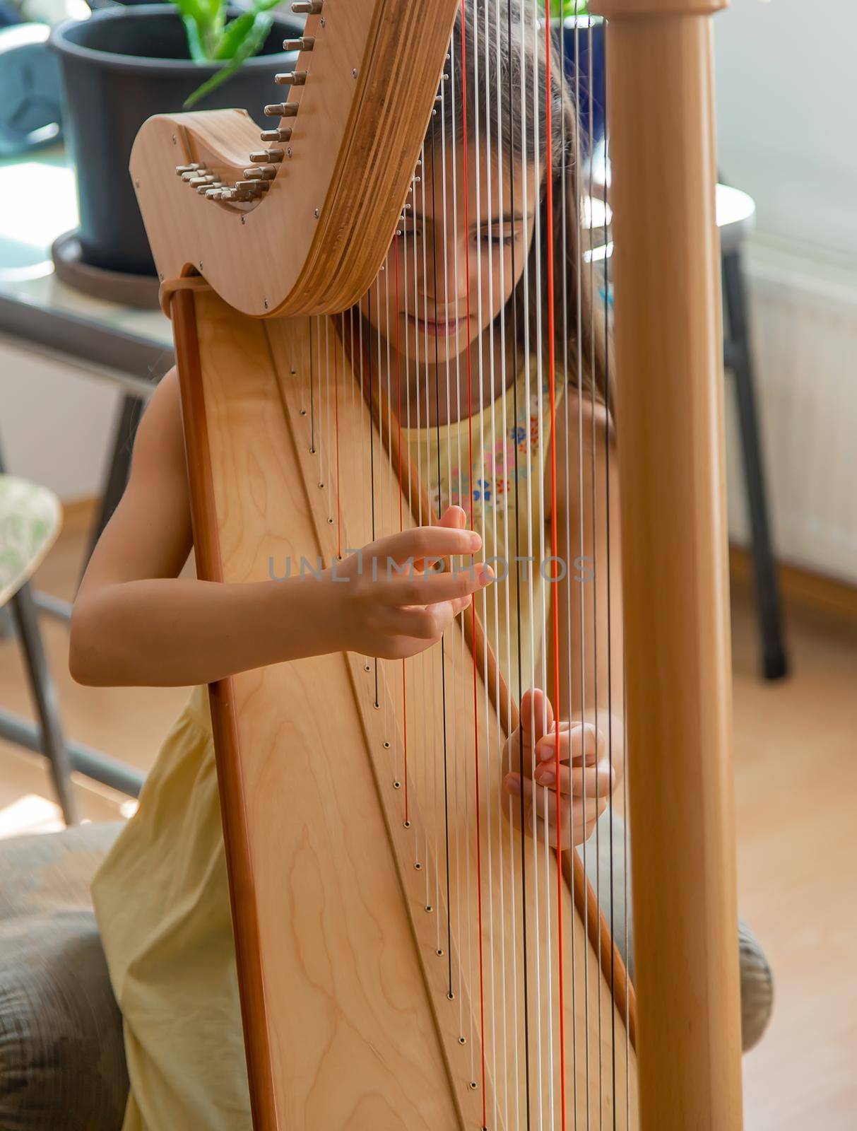 The child plays the harp. Selective focus. Kid.