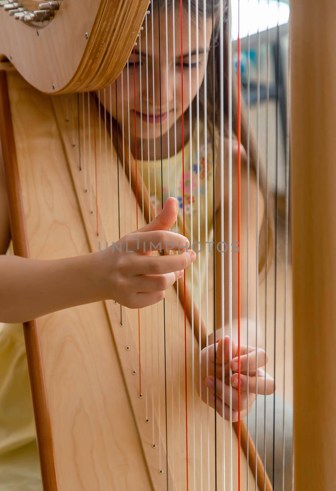 The child plays the harp. Selective focus. Kid.