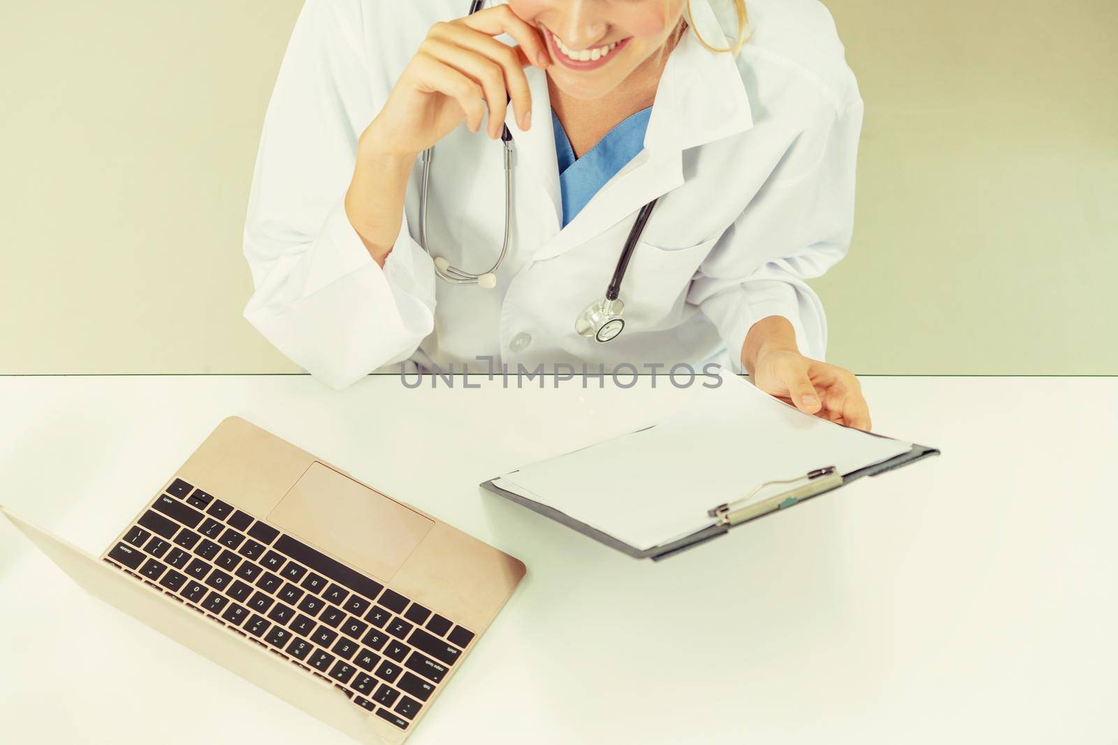Top view of young female doctor working in hospital office. Medical and healthcare concept.