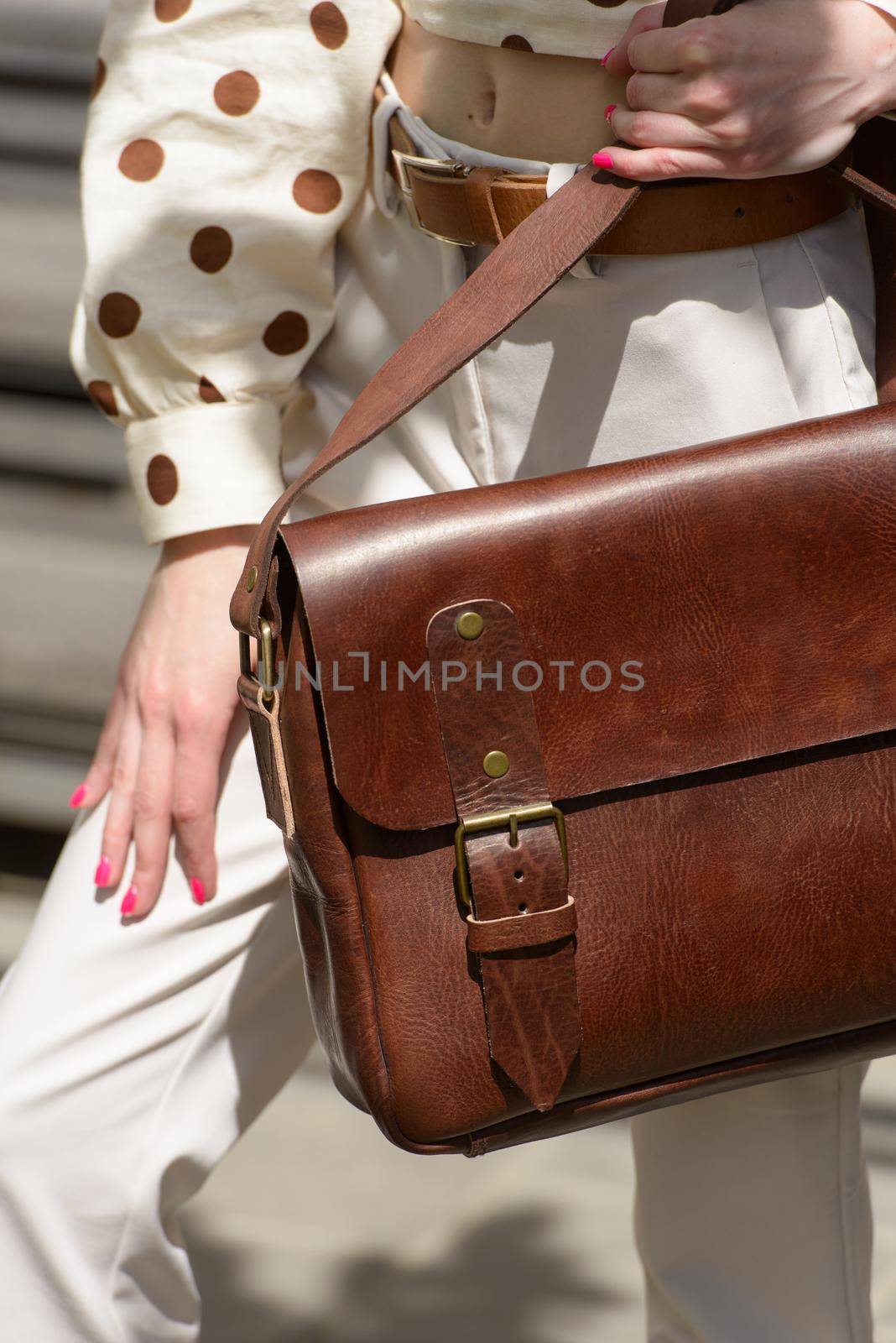 Part photo of a woman with a brown leather briefcase with antique and retro look. Outdoors photo by Ashtray25