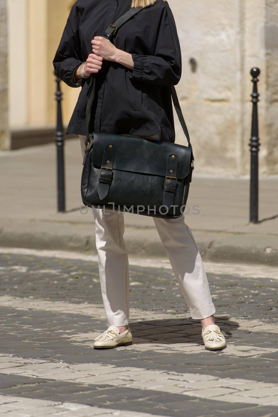 Woman with a black leather briefcase with antique and retro look. Outdoors photo.