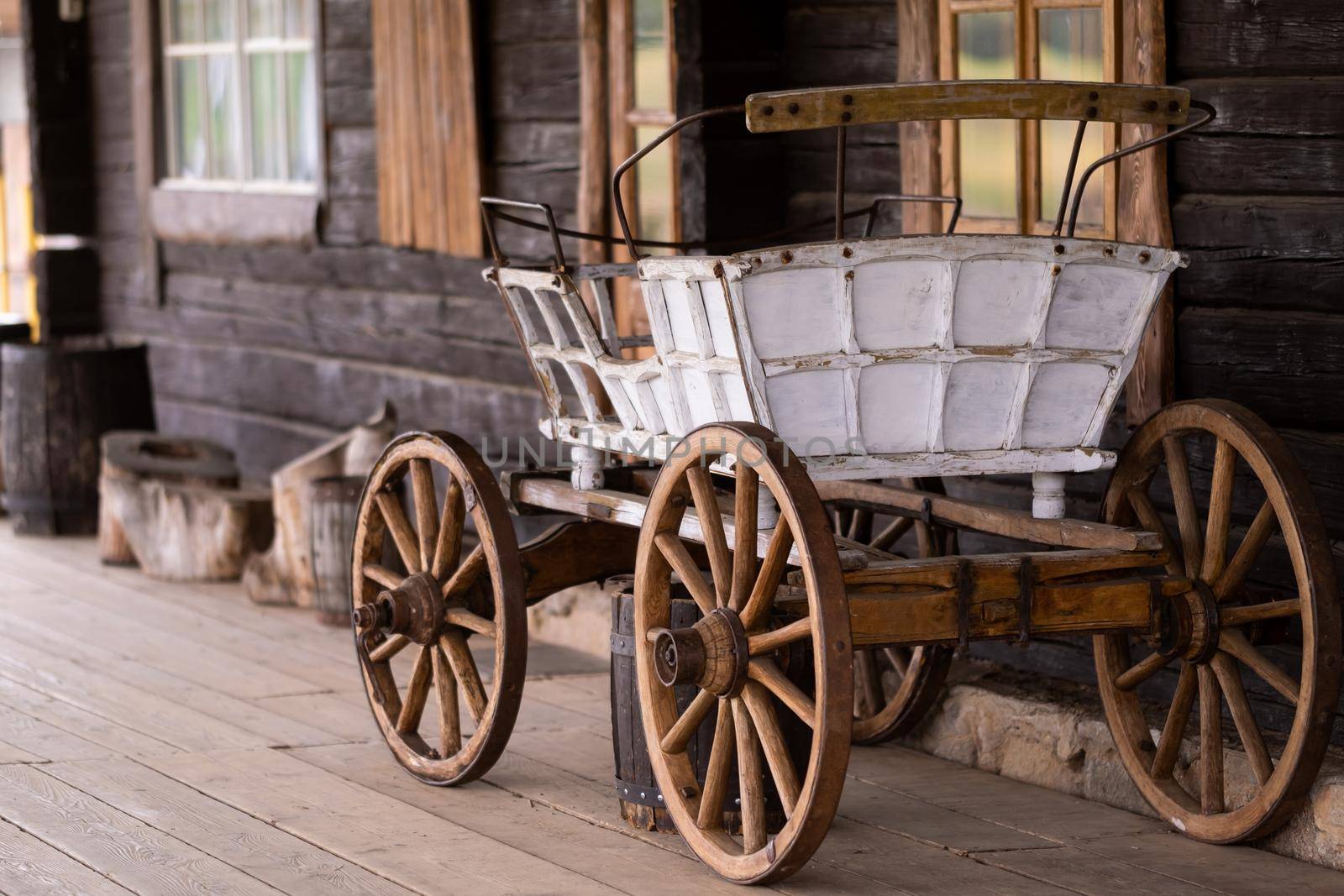 An empty antique carriage stands on a ranch in the wild West by Lobachad