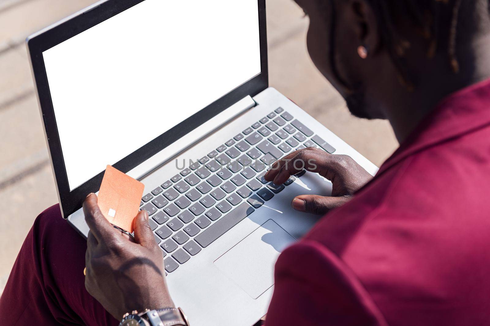 unrecognizable man paying with his credit card for the online purchase made with his laptop computer, concept of technology and online shopping