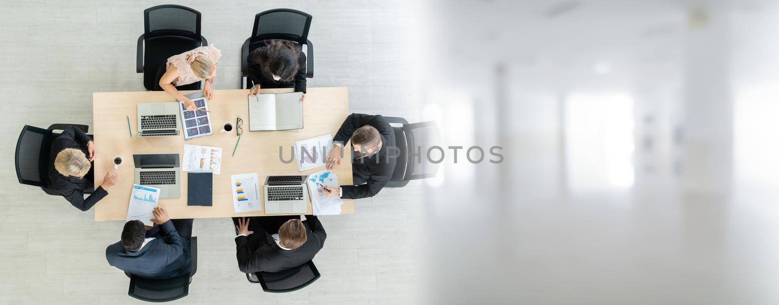 Business people group meeting shot from top widen view in office . Profession businesswomen, businessmen and office workers working in team conference with project planning document on meeting table .