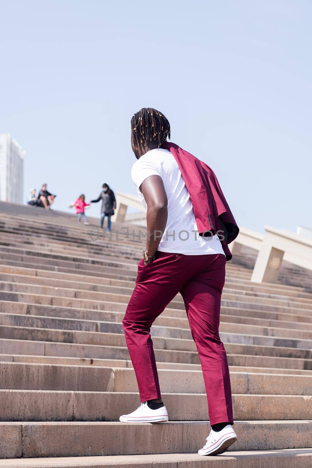 stylish black man walking up a city staircase by raulmelldo