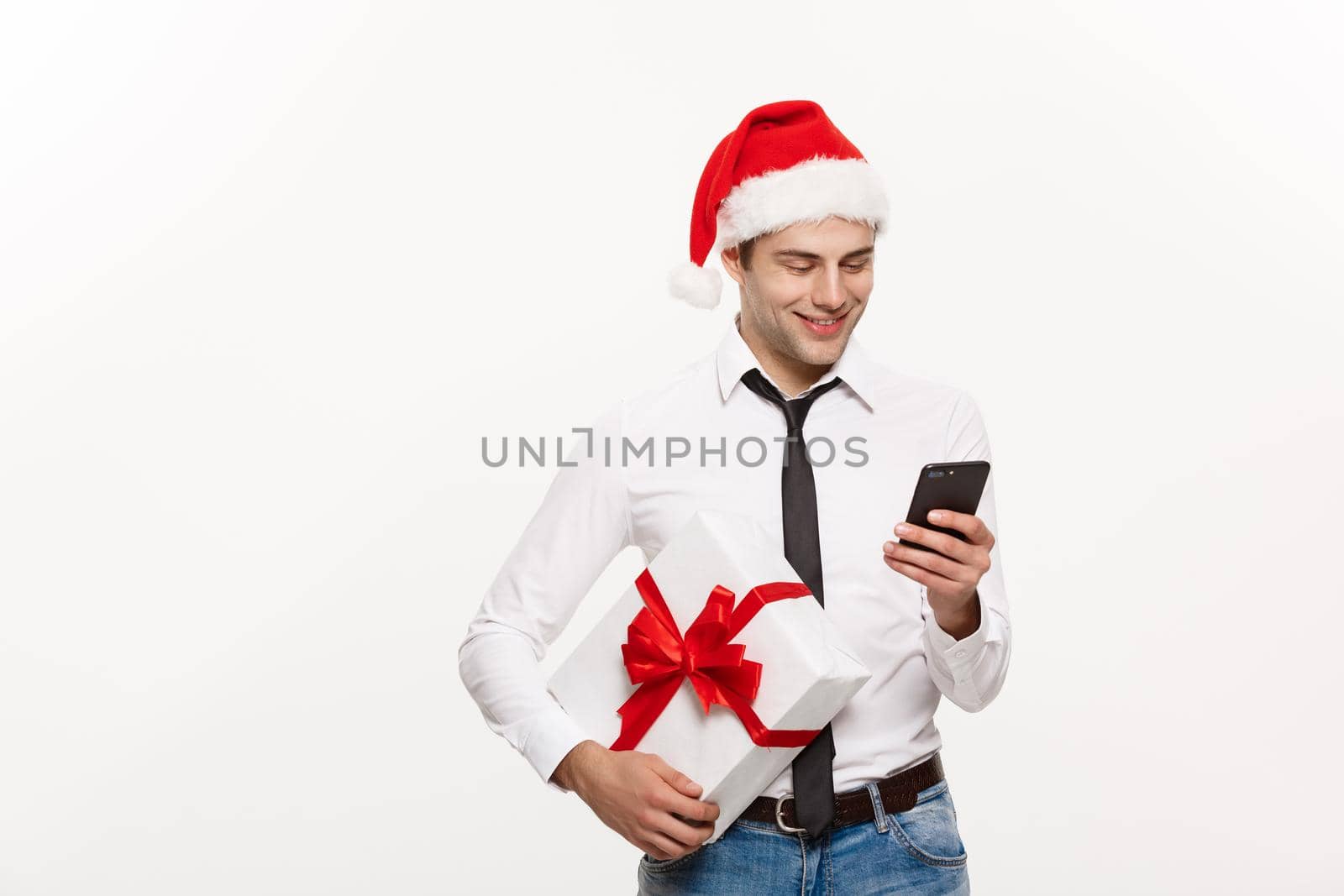 Christmas Concept - Handsome Business man talking on phone and holding glass of champange celebrating Chirstmas and New year.