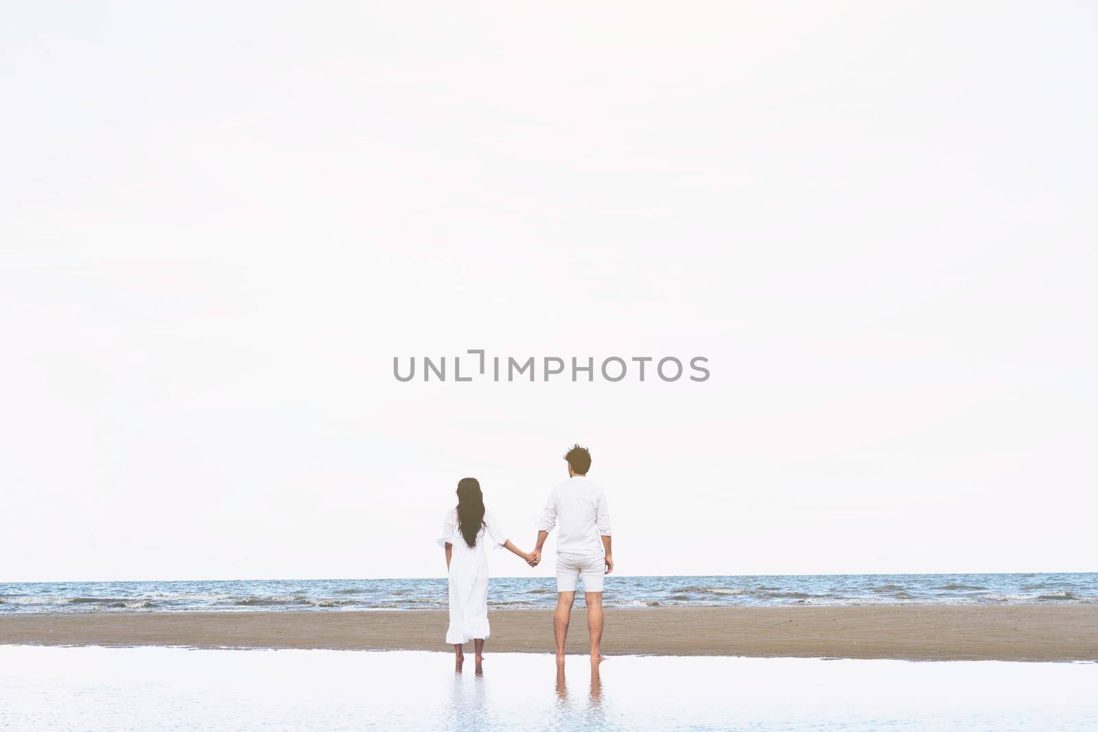Couple going honeymoon on tropical beach in summer by biancoblue