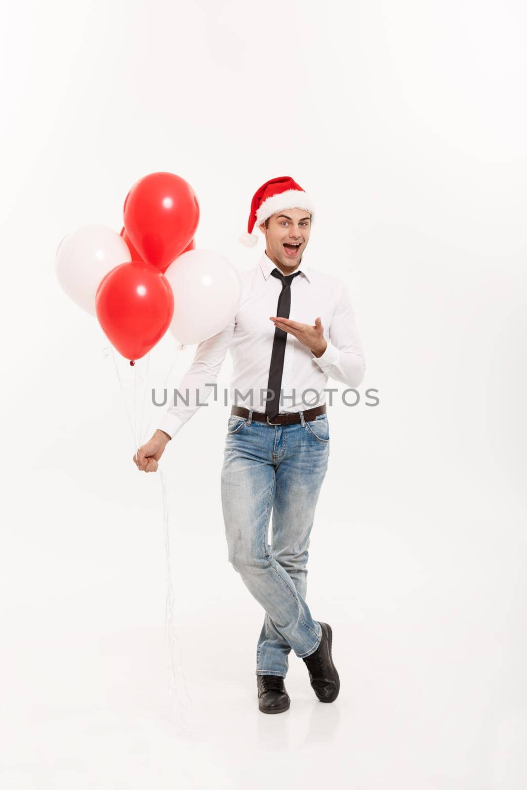 Christmas Concept - Handsome happy Business man wear santa hat giving red balloon for merry christmas and happy new year wear santa hat. by Benzoix