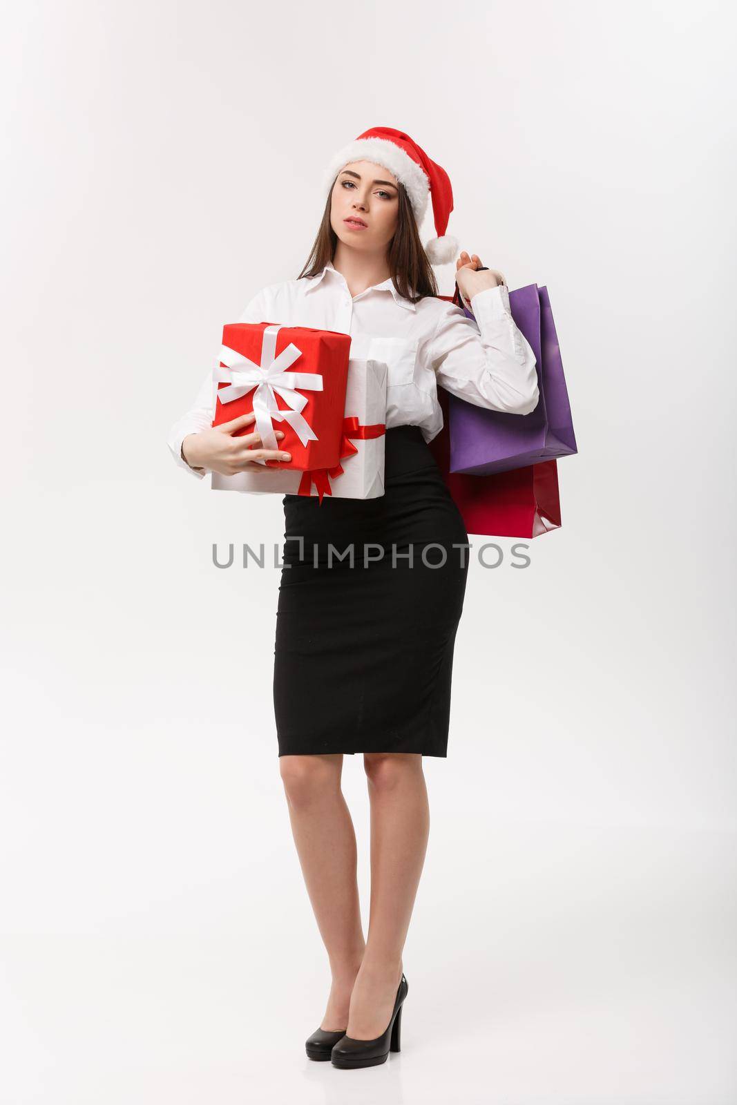 Christmas Concept - beautiful business woman holding shopping bags and present with exhausted feeling. by Benzoix