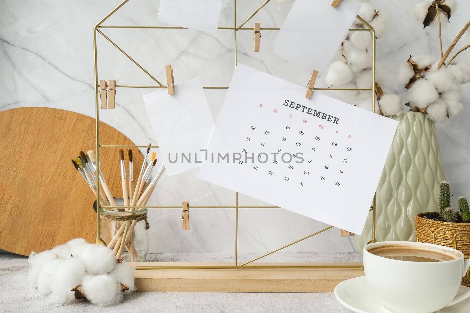 SEPTEMBER CALENDAR Cards and posters mock ups on grid board. Copy space. Home office desktop. Freelance bloggers workplace. Brushes and palette tools Creative