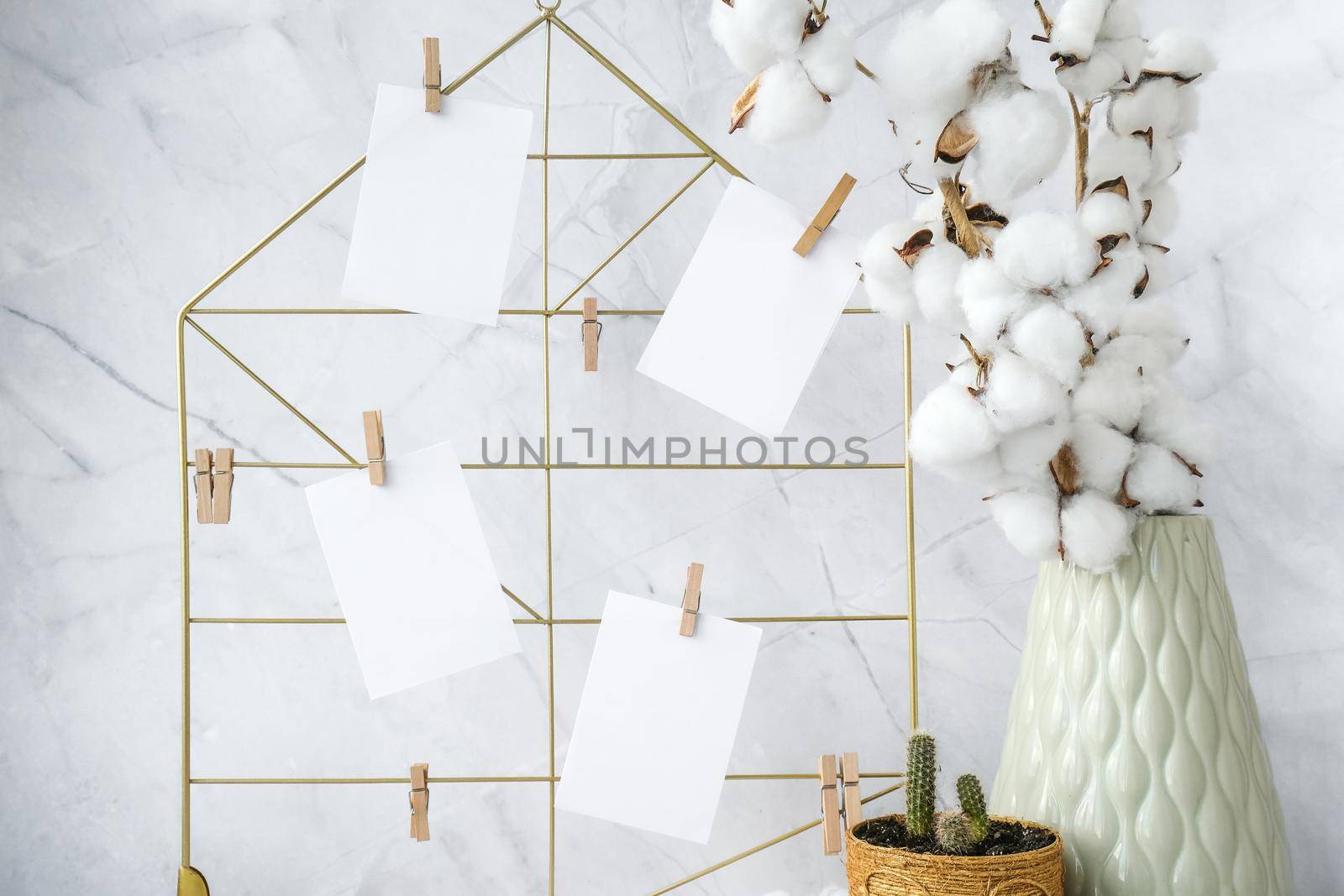 Cards and posters mock ups on grid board. Copy space. Feminine hipster office table decoration. Home office desktop. Freelance bloggers workplace. Cactuses