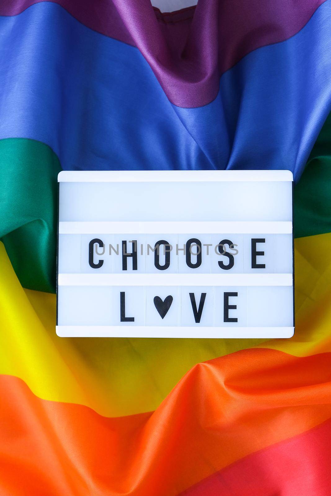 Rainbow flag with lightbox and text CHOOSE LOVE. Rainbow lgbtq flag made from silk material. Symbol of LGBTQ pride month. Equal rights. Peace and freedom by anna_stasiia