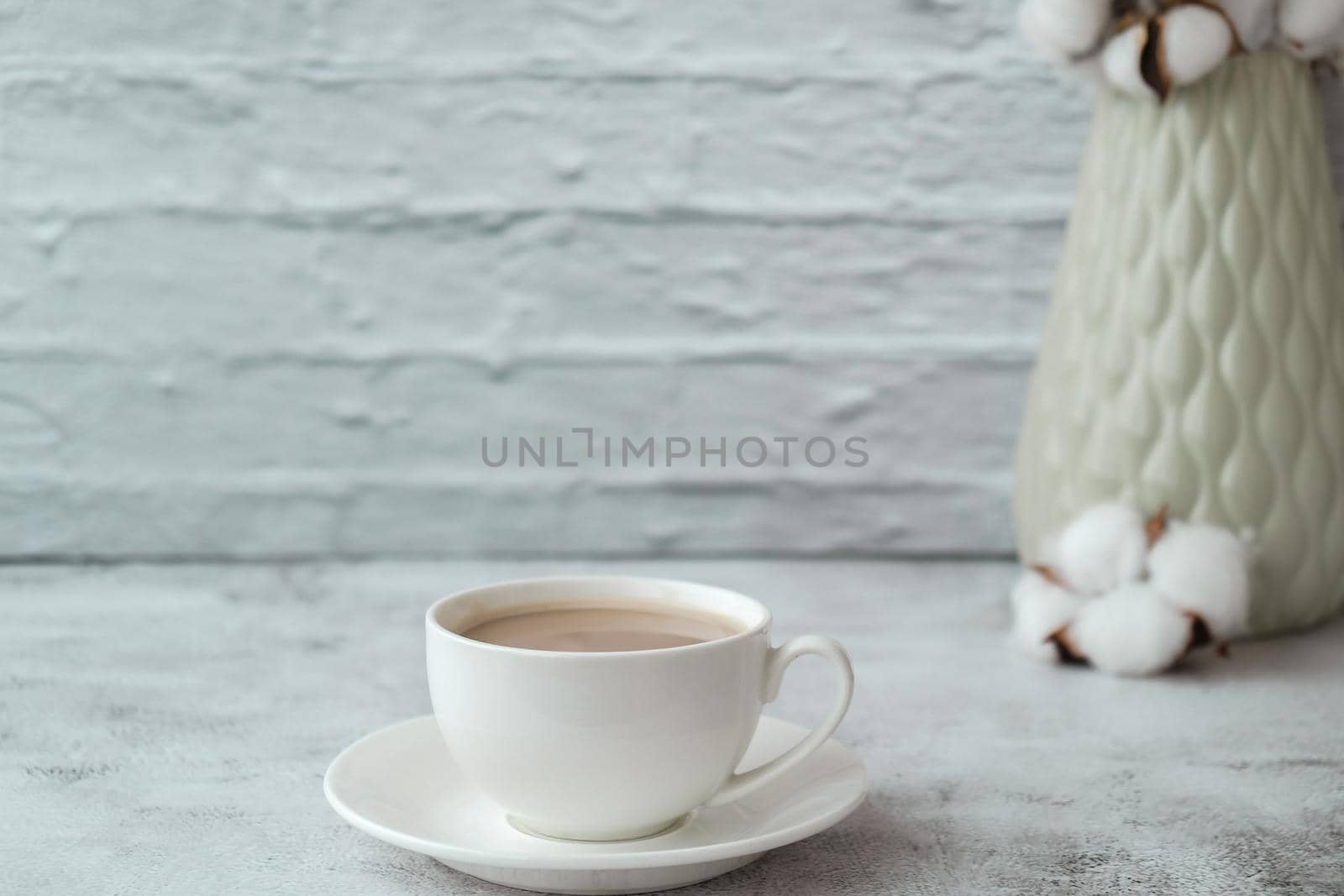 Cup of coffee with vase and cottons on rustic concrete background. Copy space. Home interior. by anna_stasiia