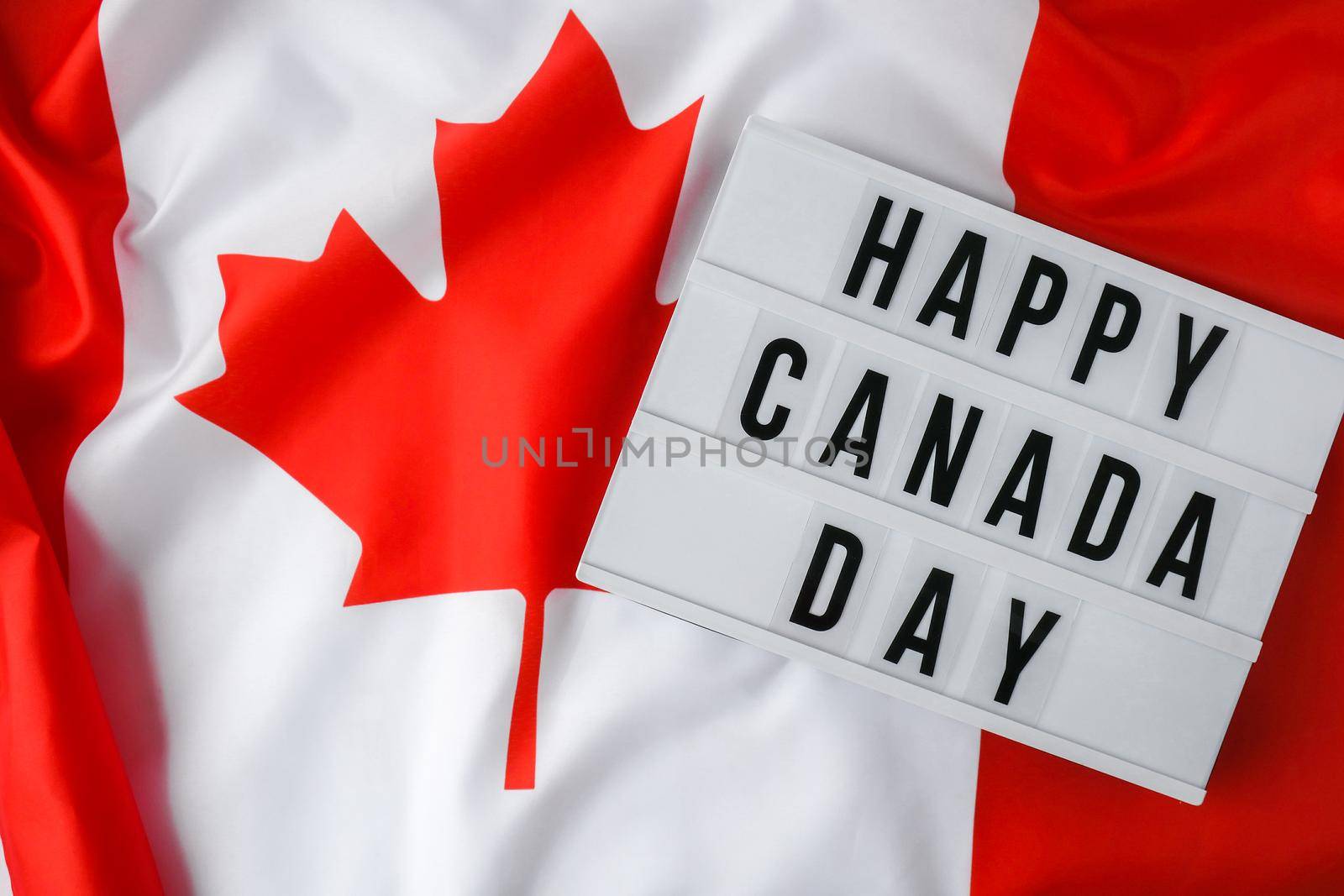 The National Flag of Canada. Lightbox with text HAPPY CANADA DAY Canadian Flag or the Maple Leaf. Patriotism. International relations concept. Independence day. Immigration