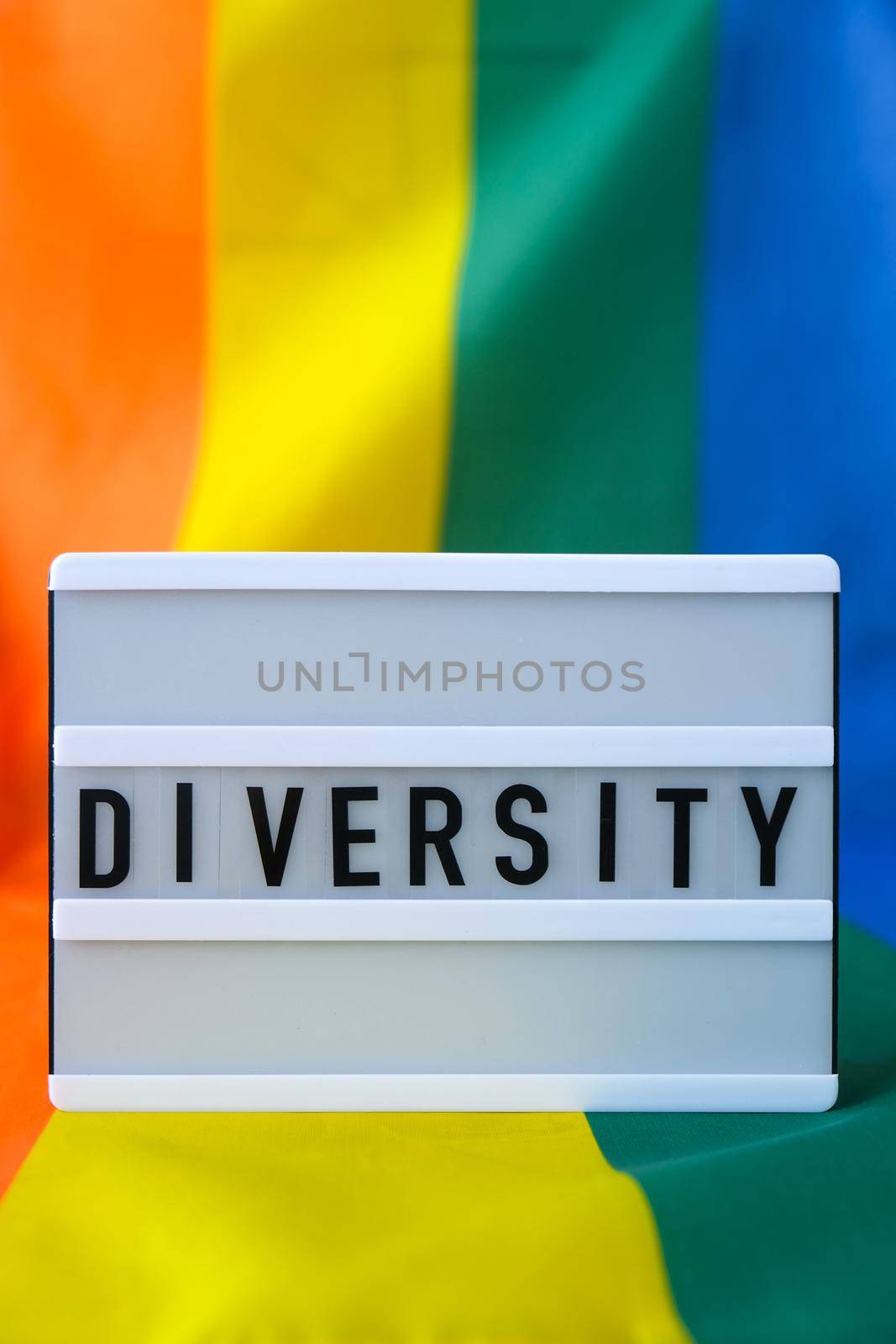 Rainbow flag with lightbox and text DIVERSITY. Rainbow lgbtq flag made from silk material. Symbol of LGBTQ pride month. Equal rights. Peace and freedom. Support LGBTQ community