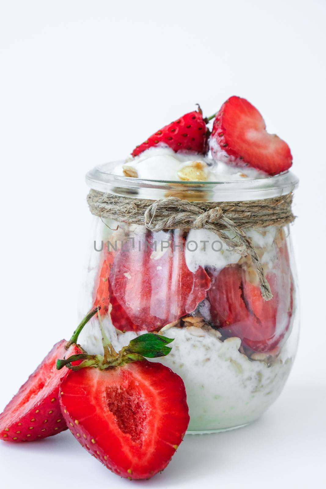 Healthy breakfast. Oatmeal Granola with greek yogurt and nuts strawberry muesli in jars on light background. Vegan, vegetarian and weight loss diet concept. Detox menu. Healthy eating food