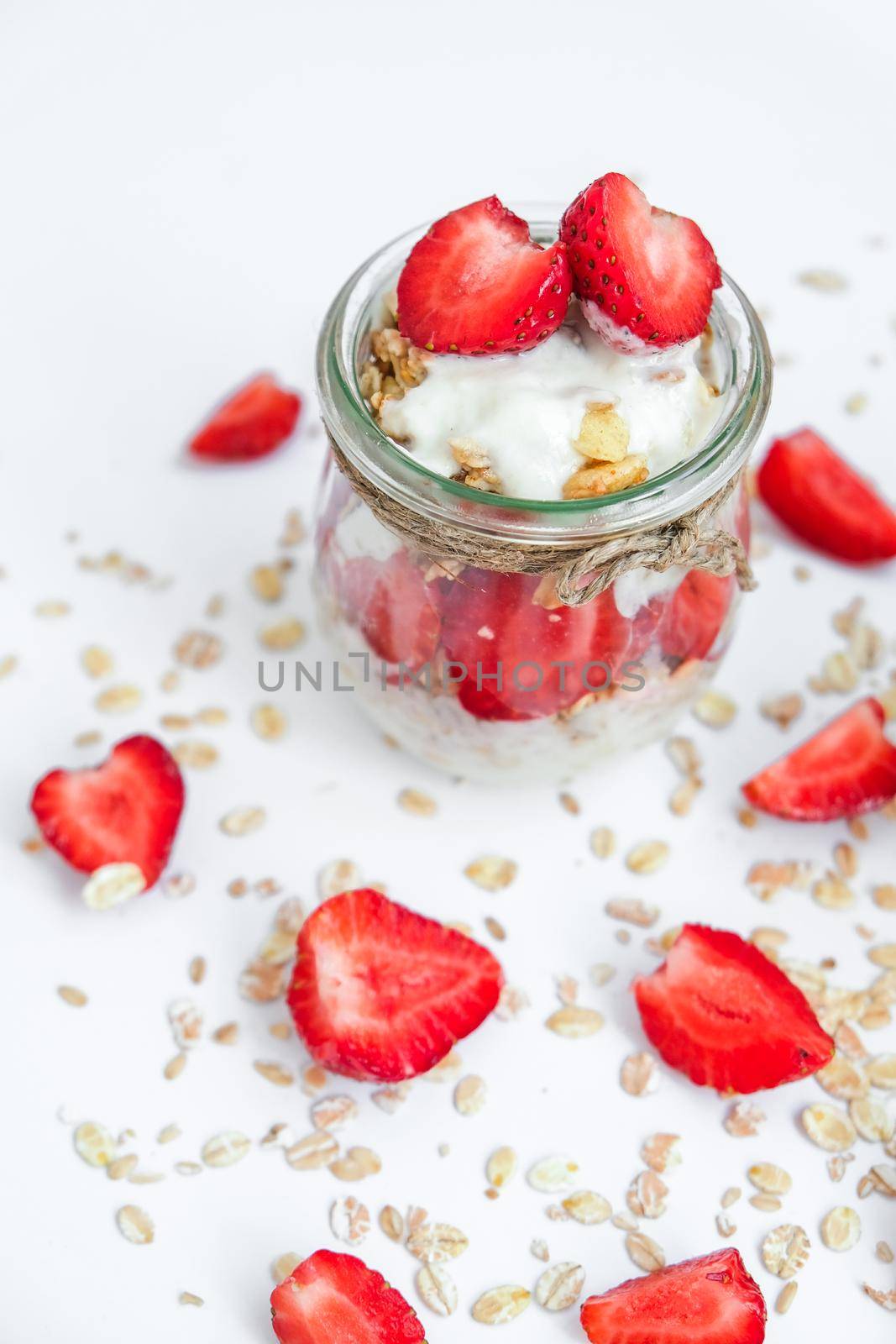 Healthy breakfast. Oatmeal Granola with greek yogurt and nuts strawberry muesli in jars on light background. Vegan, vegetarian and weight loss diet concept. Detox menu. by anna_stasiia