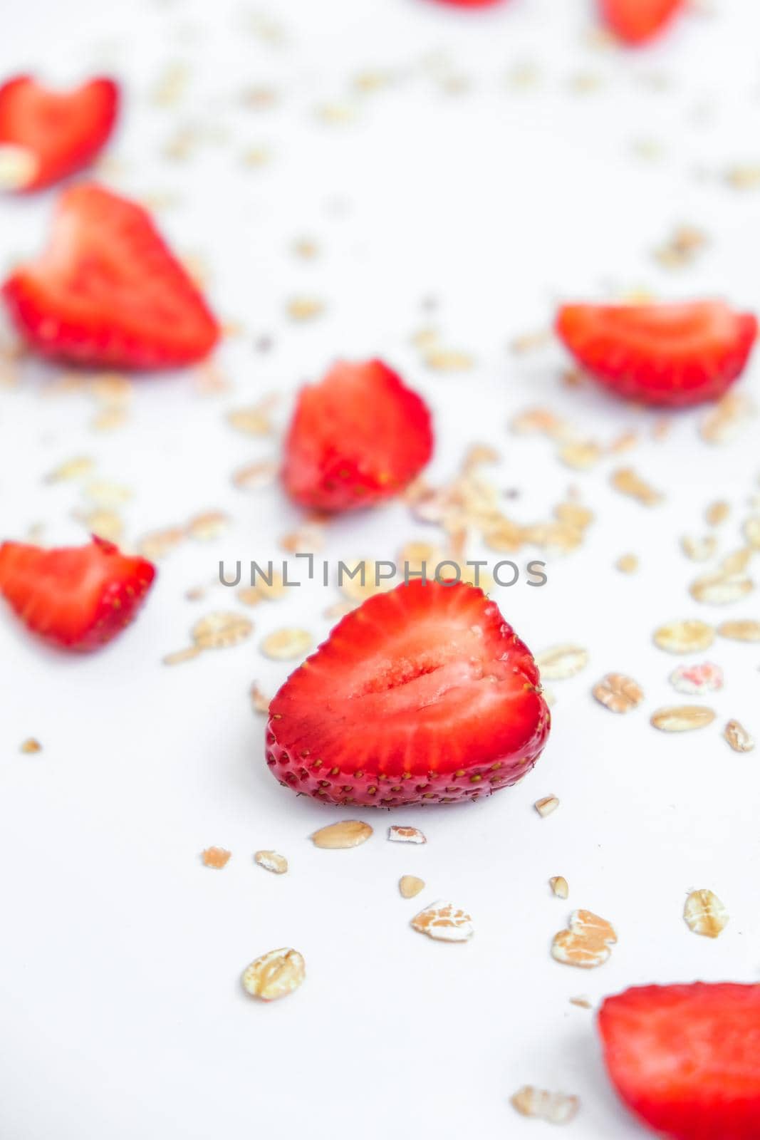 Oatmeal porridge with fresh strawberries on light table. Healthy diet breakfast, vegan or vegeterian food concept. Food background. Oat granola