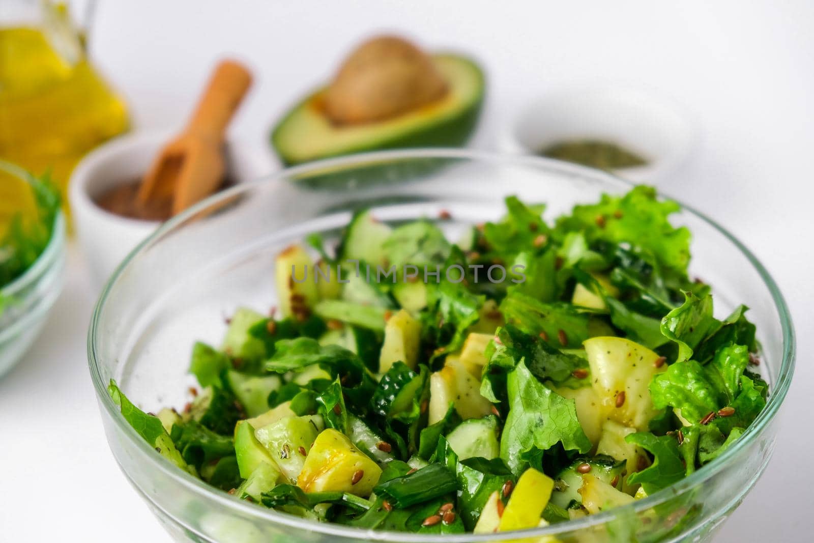 Salad of fresh green vegetables and herbs. Cooking healthy diet or vegetarian food. Step by step recipe. Healthy eating. Ingredients for salad. Raw food concept. A variety of organic fruits and vegetables with avocado. Vegan menu. Fresh spinach and green onion leaves, arugula. Flax seeds